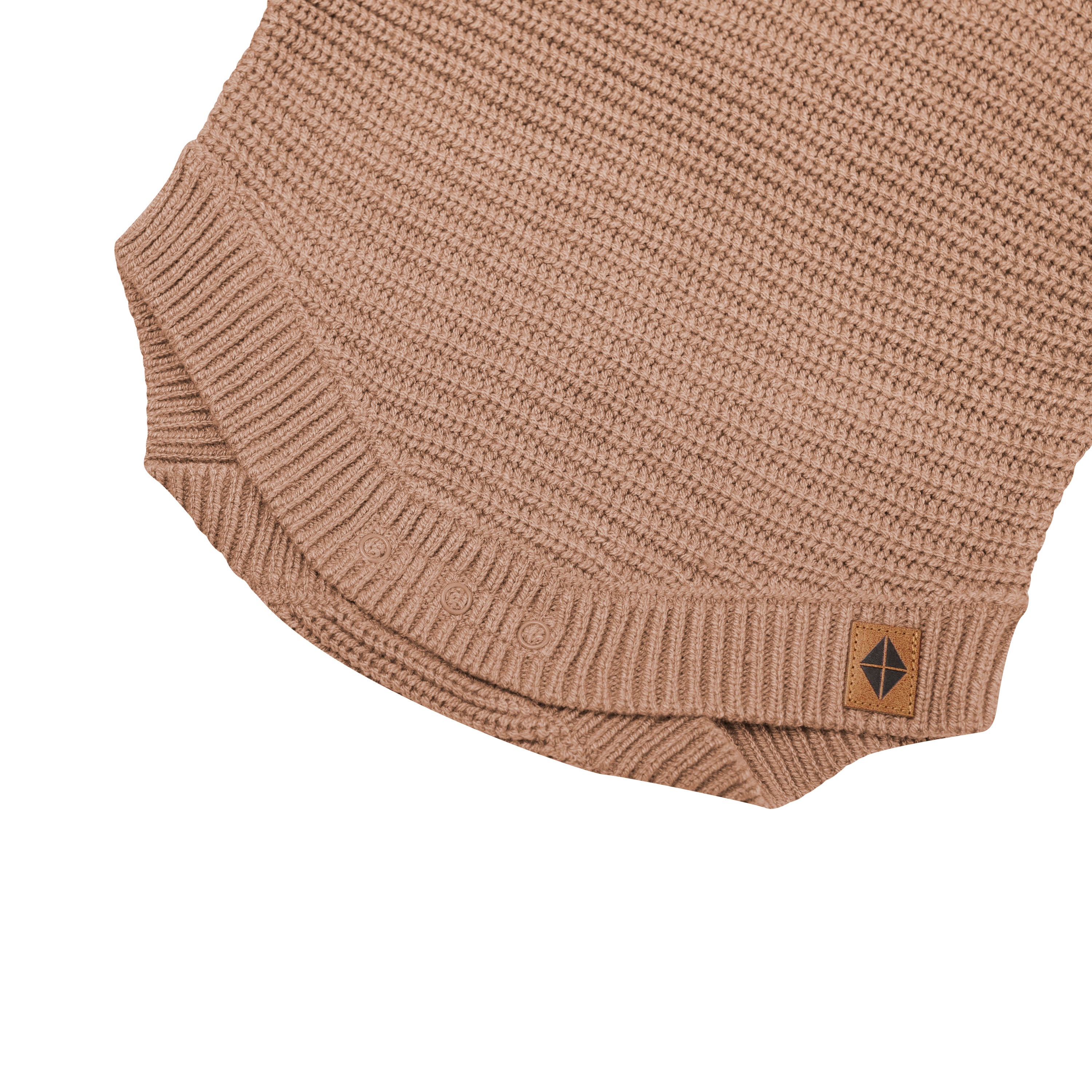 Close up of the snap closures shown on the Chunky Knit Romper in Latte with the Kyte Baby vegan leather tag visible