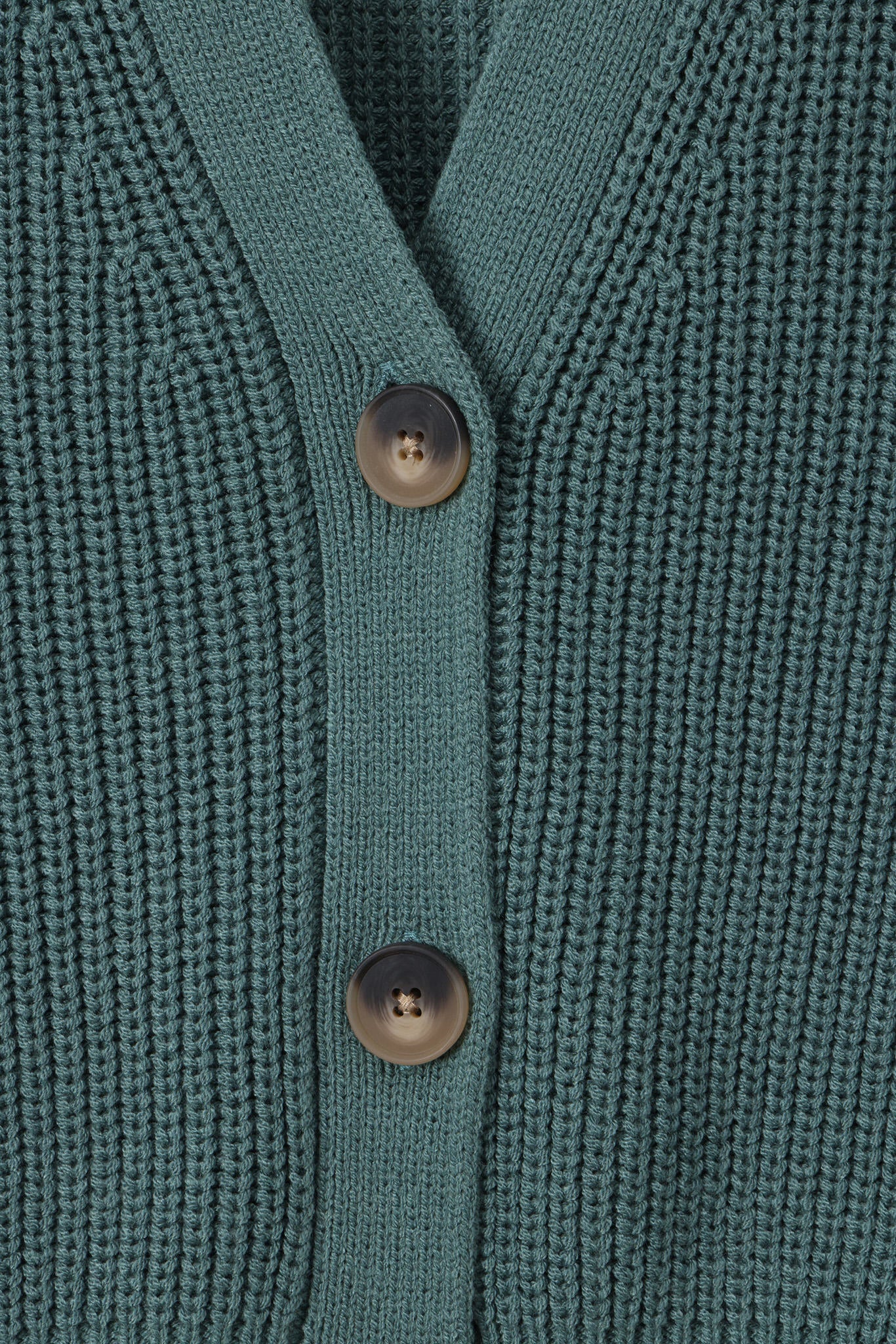 Close-up of a teal green ribbed knit cardigan sweater showing the button placket with two dark brown buttons.