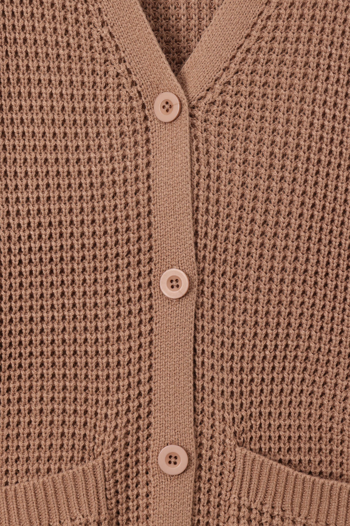 Close-up of a brown waffle-knit cardigan sweater showing the button-up front with matching buttons and ribbed trim.