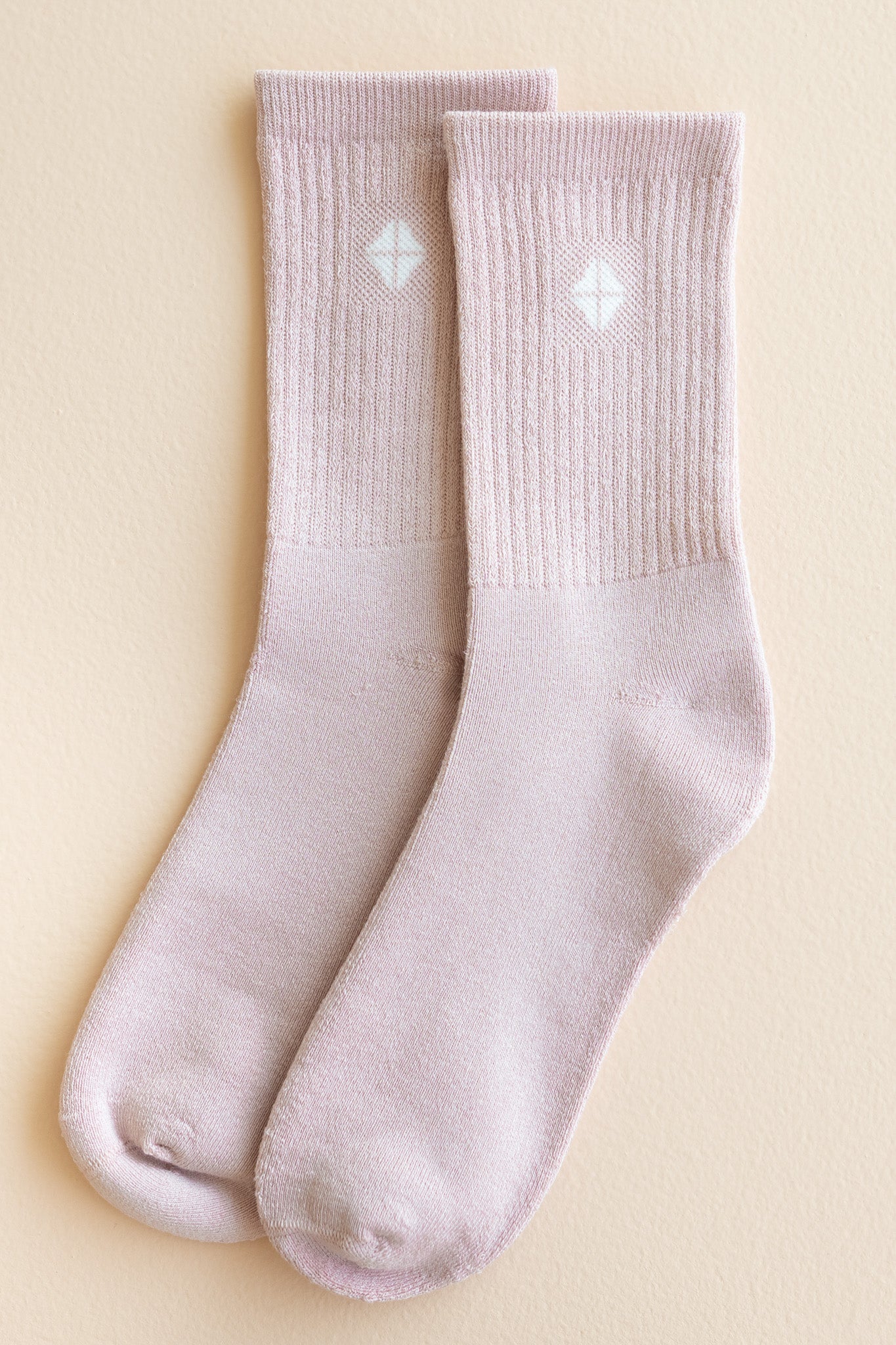 Adult Crew Socks in Blush shown out of package laying side by side on a light beige surface