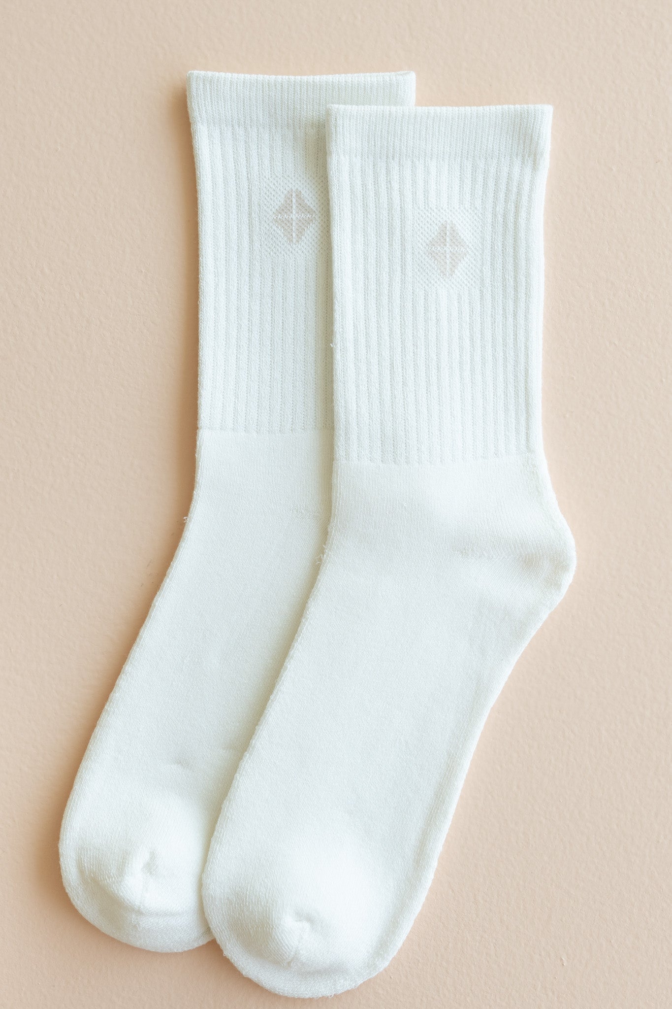 Adult Crew Socks in Cloud shown out of package laid side by side on a light beige surface