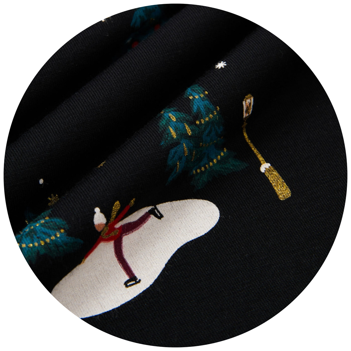 A close-up circular view of black fabric with a printed winter holiday pattern, including a skater on white snow, teal trees with gold ornaments, and a gold-and-white lantern.