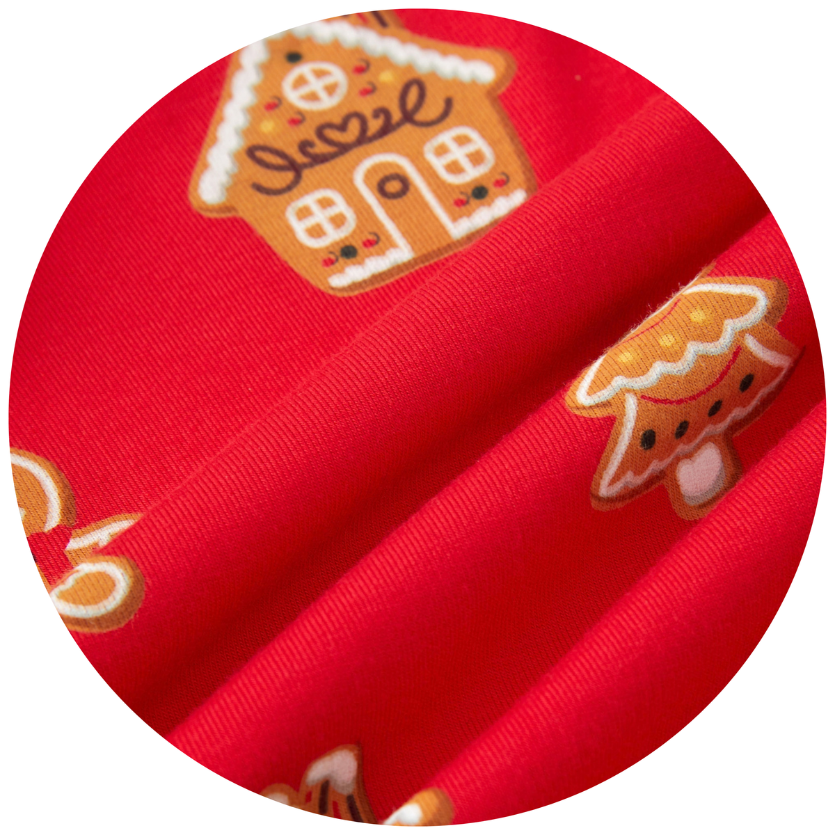 A close-up circular view of bright red fabric with a repeating gingerbread house and gingerbread tree print, showing the material texture and pattern detail.