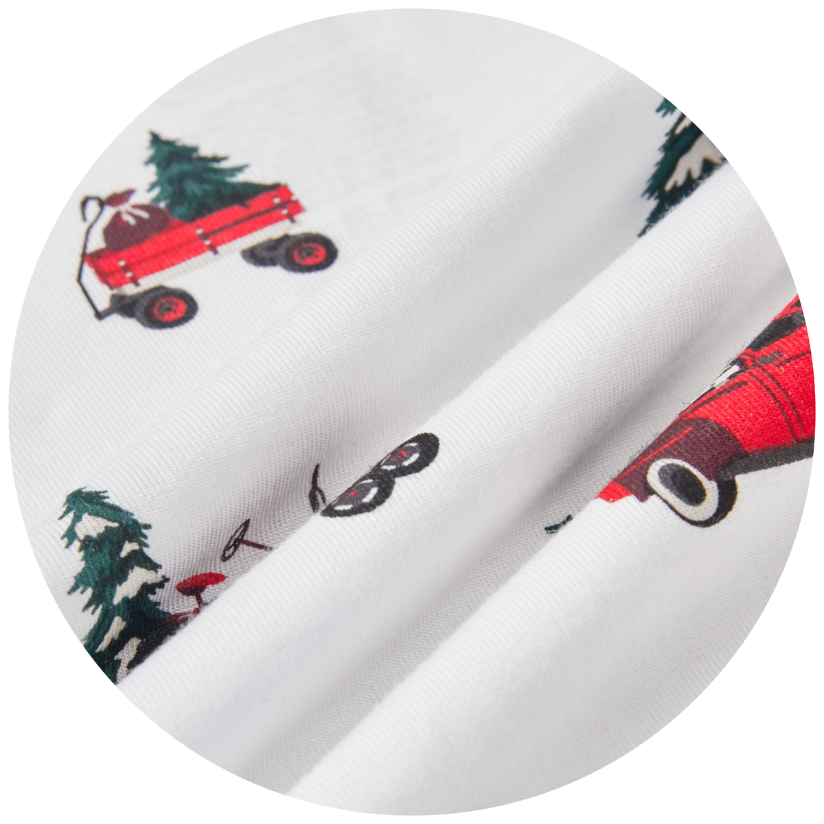 White fabric with a festive holiday print featuring red vintage trucks carrying Christmas trees, green pine trees, and a Santa Claus figure, shown in a circular close-up.