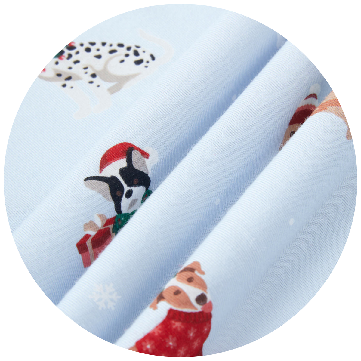 A close-up circular view of light blue fabric with a holiday dog print, showing rolled layers of the material and cartoon dogs in red Santa hats with snowflake details.