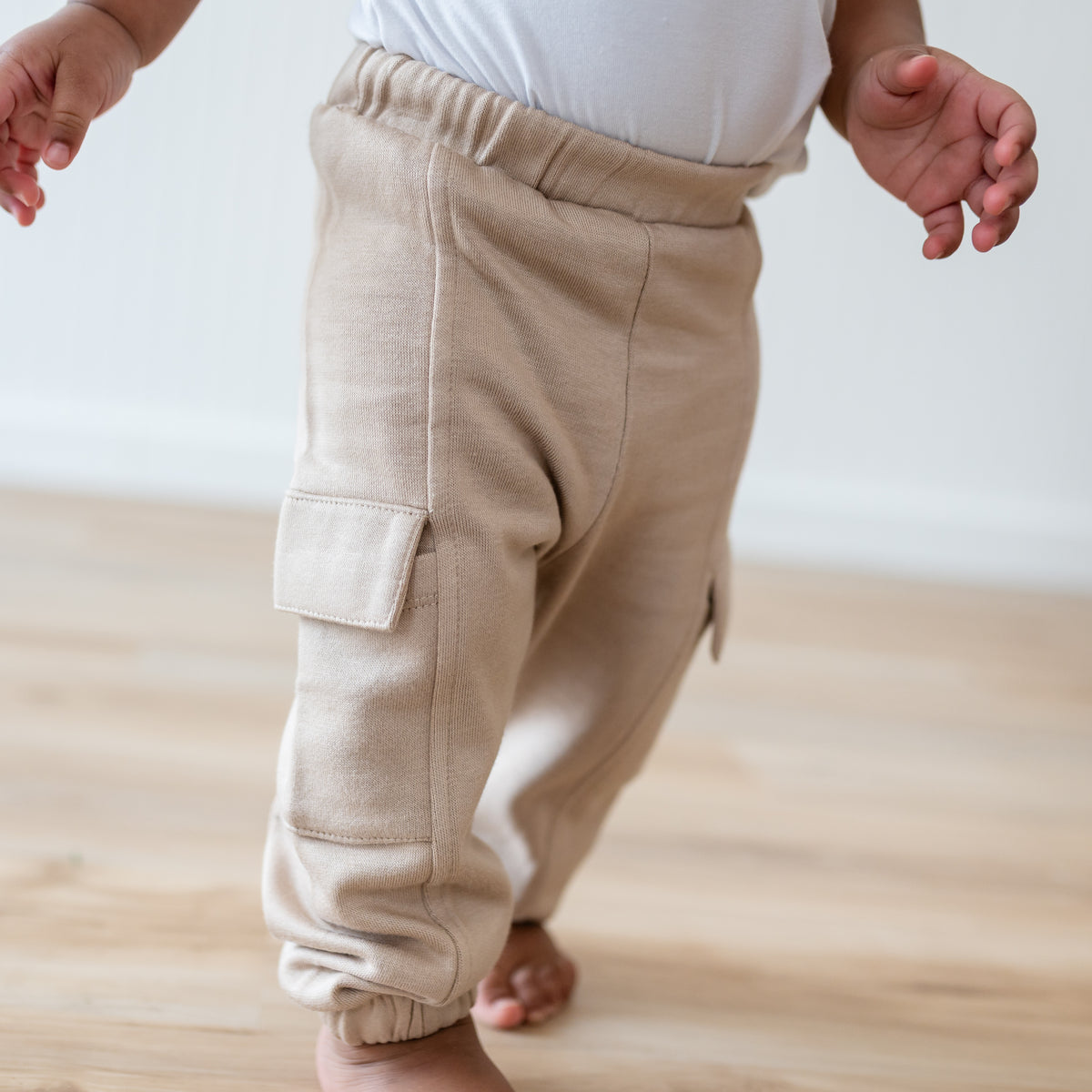 Close up of the Fleece Cargo Pants in Almond shown on a walking toddler