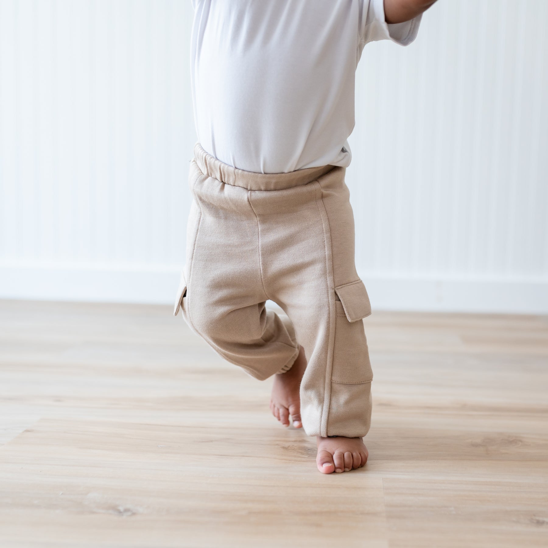 Close up of the Fleece Cargo Pants in Almond shown on a walking toddler