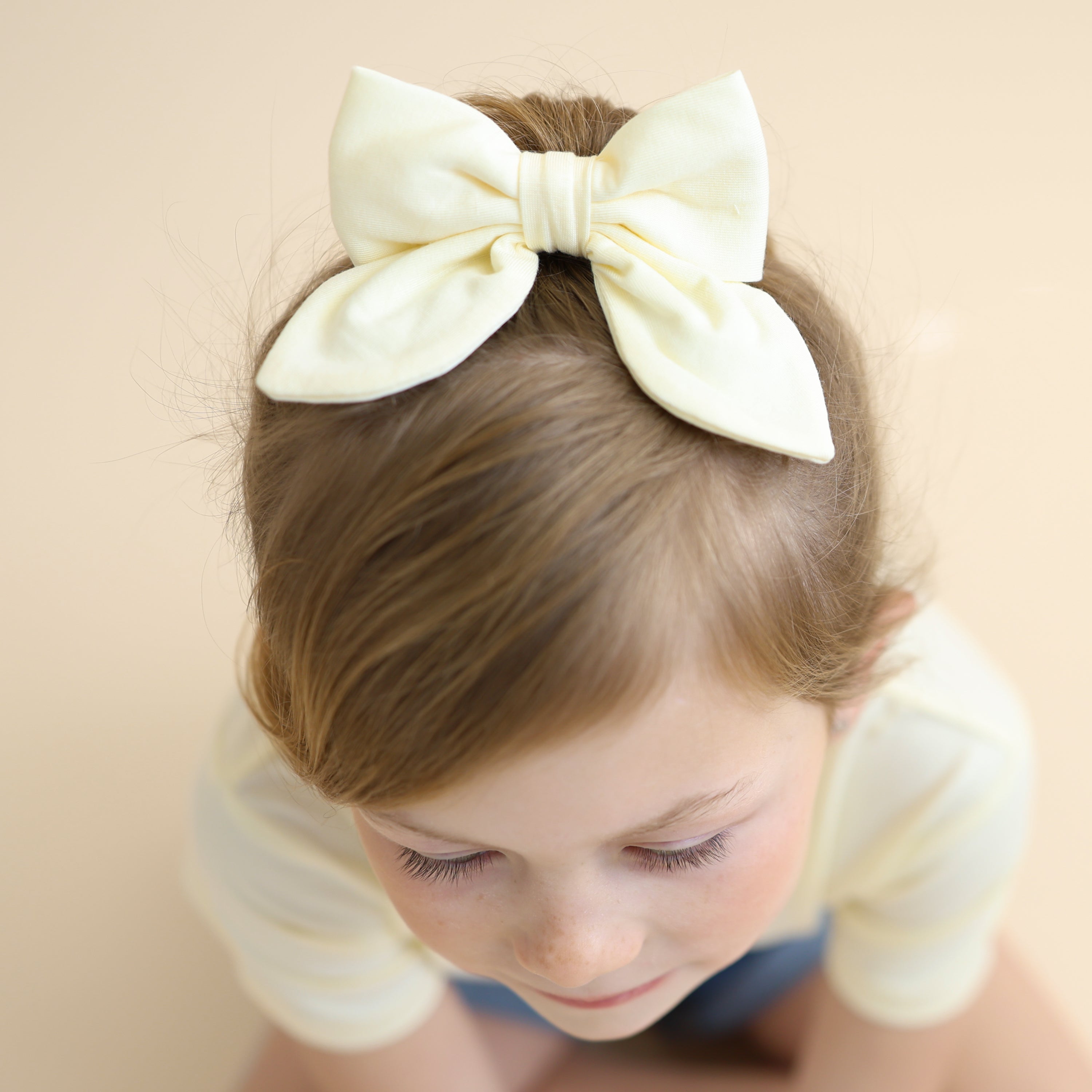 Close up of the Medium Alligator Clip Bow in Chamomile shown in a young girls hair