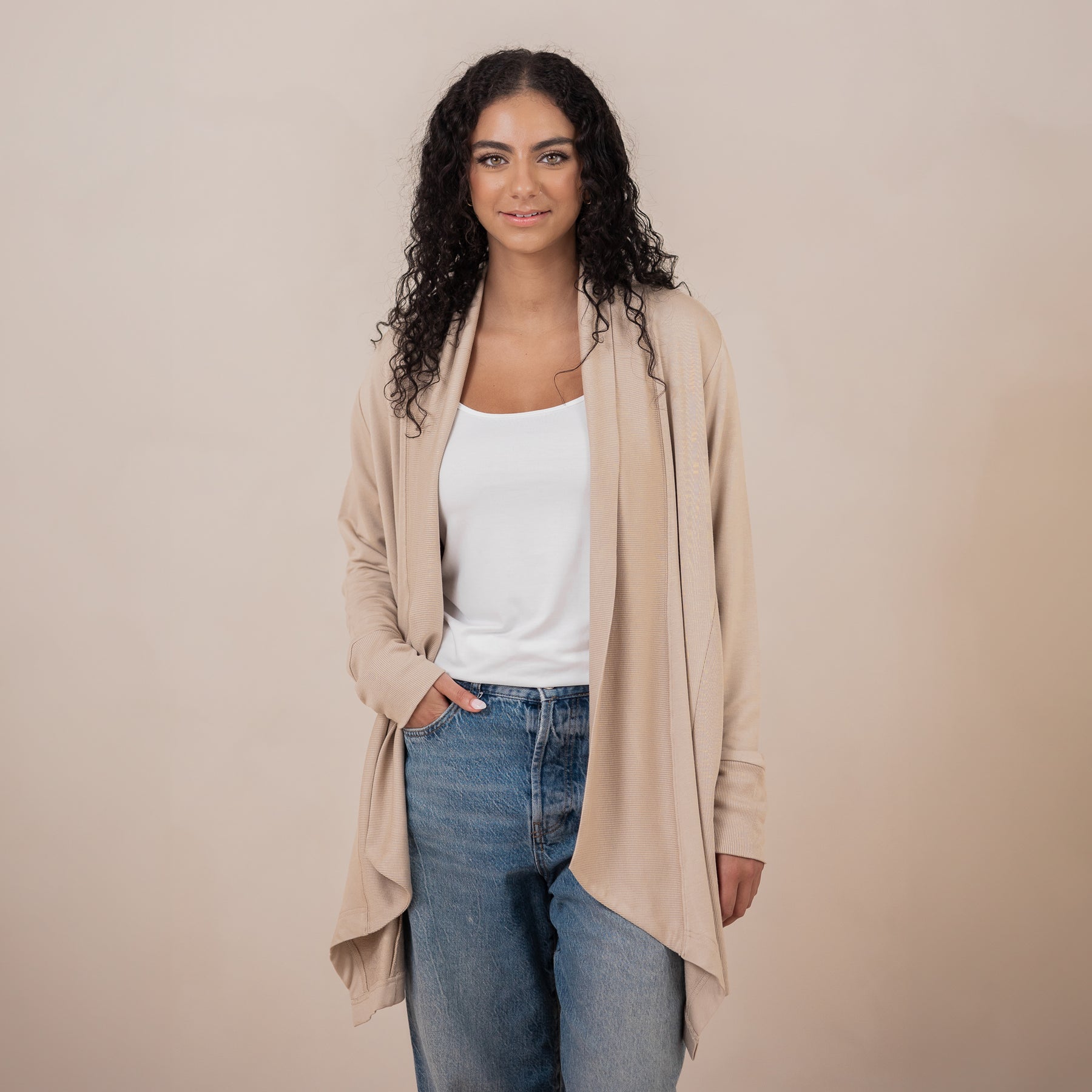 Female wearing the Women's French Terry Wrap Top in Almond with a white shirt and medium wash jeans