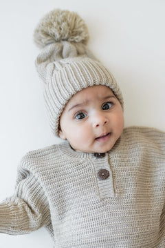 Close up of the Chunky Cable Knit Beanie in Almond shown on an infant wearing the Chunky knit romper in Almond