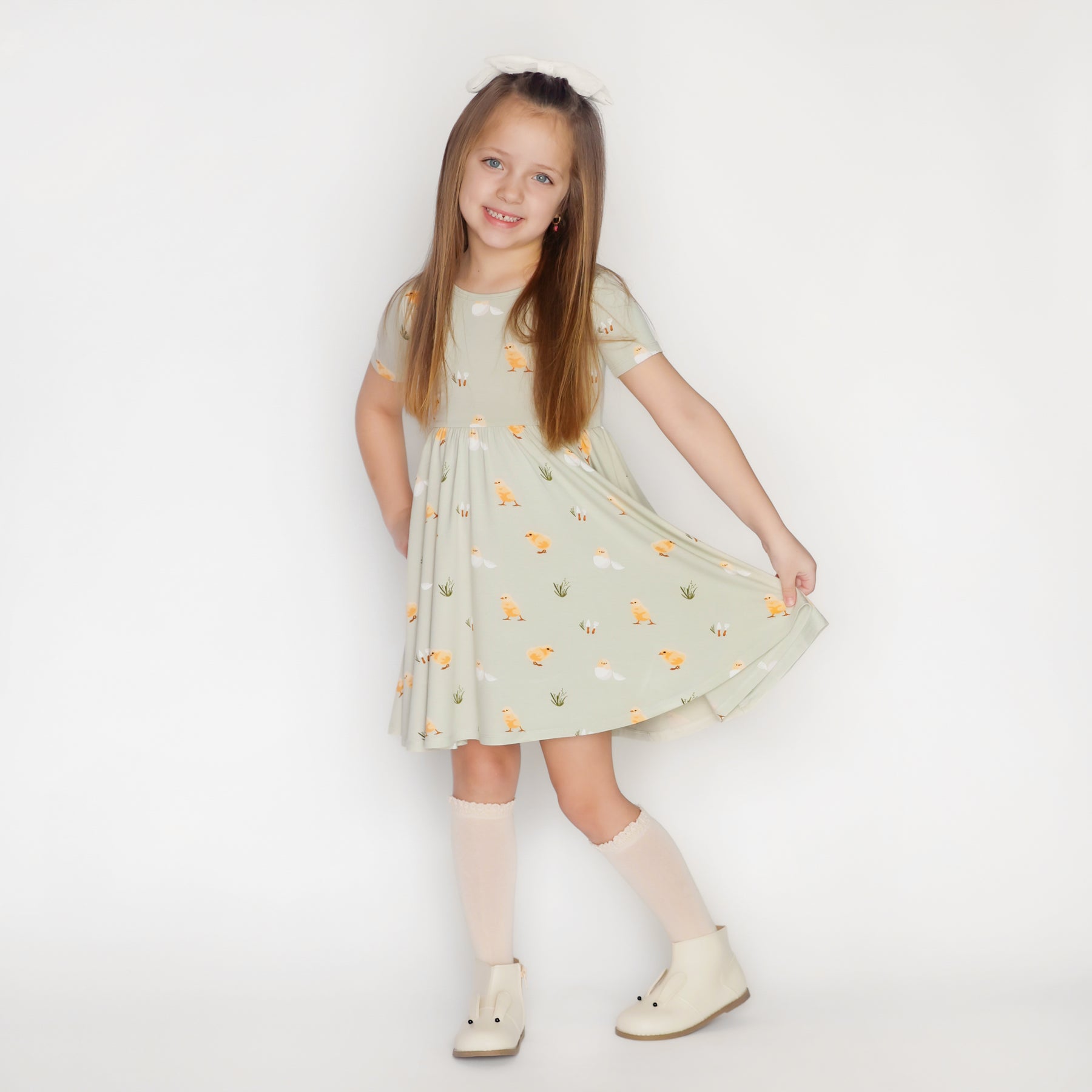 Child wearing Twirl Dress in Aloe Chick