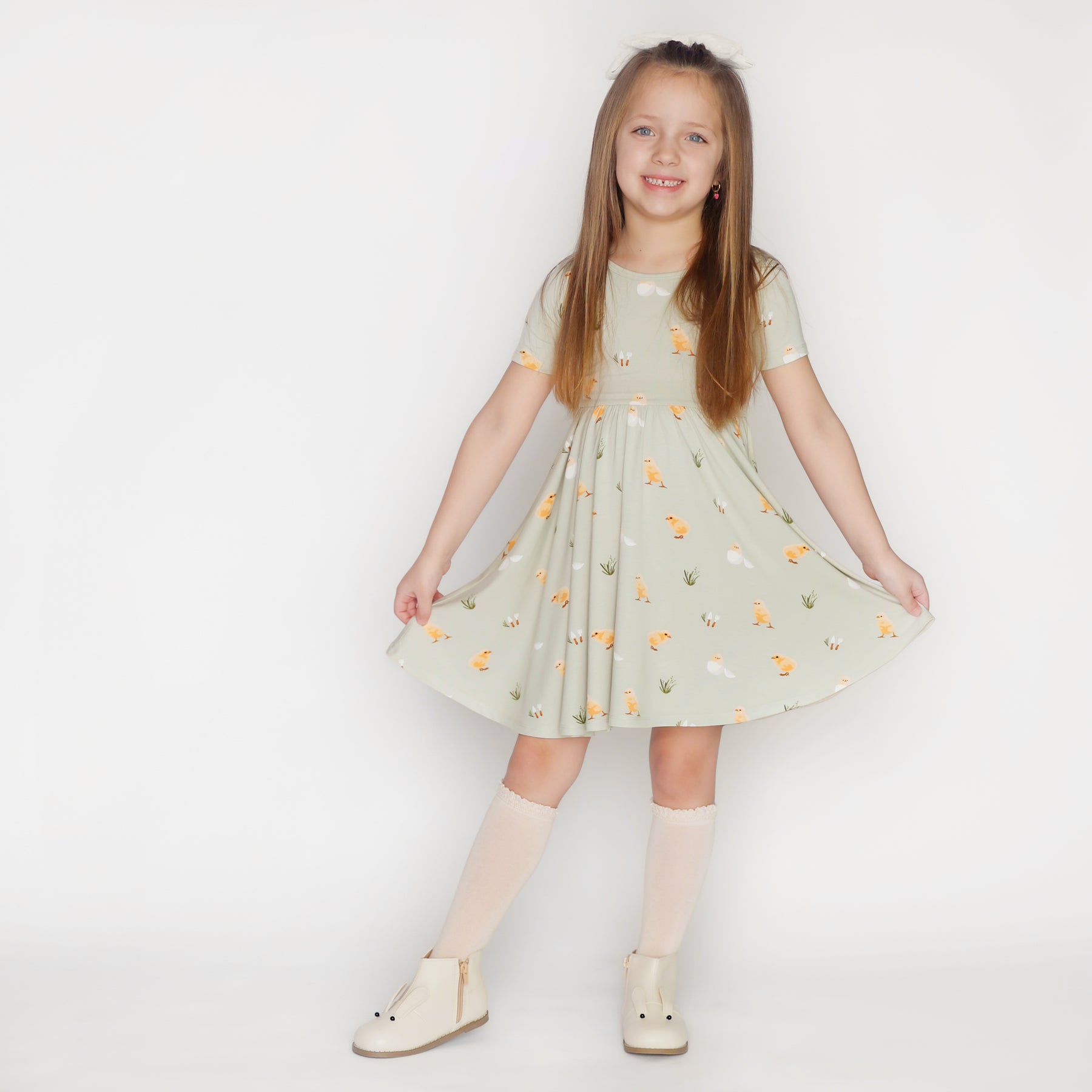 Child wearing Twirl Dress in Aloe Chick