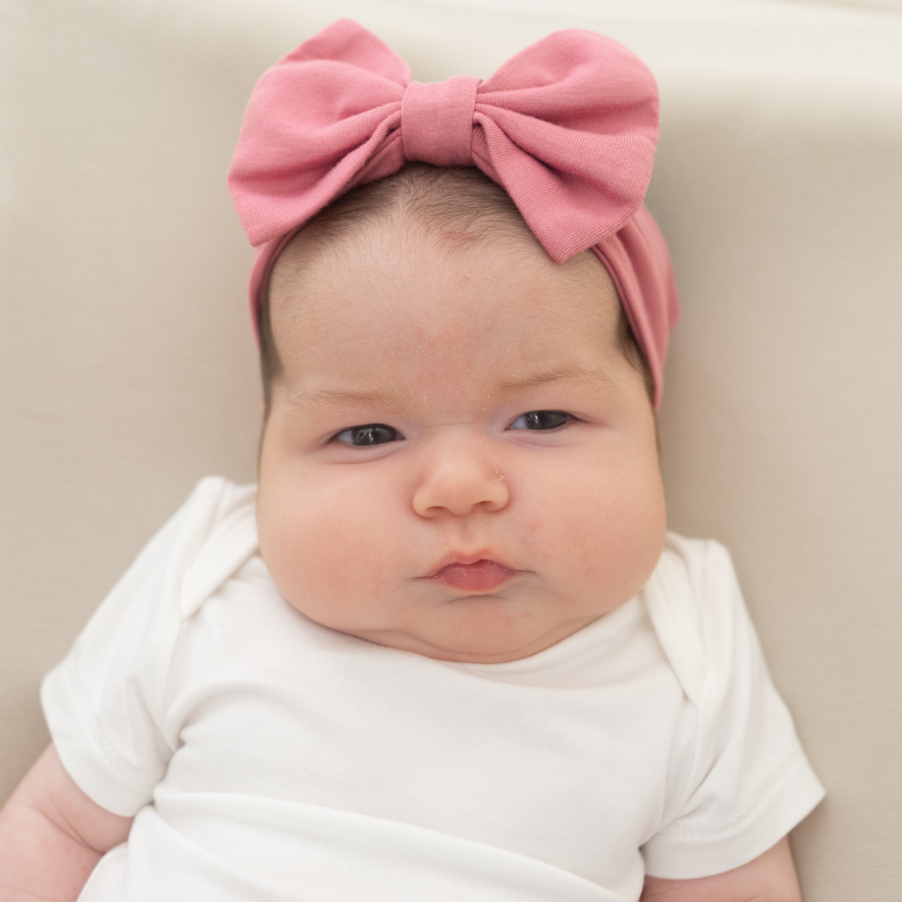 Baby wearing Bow Headband in Apple Blossom with white bodysuit