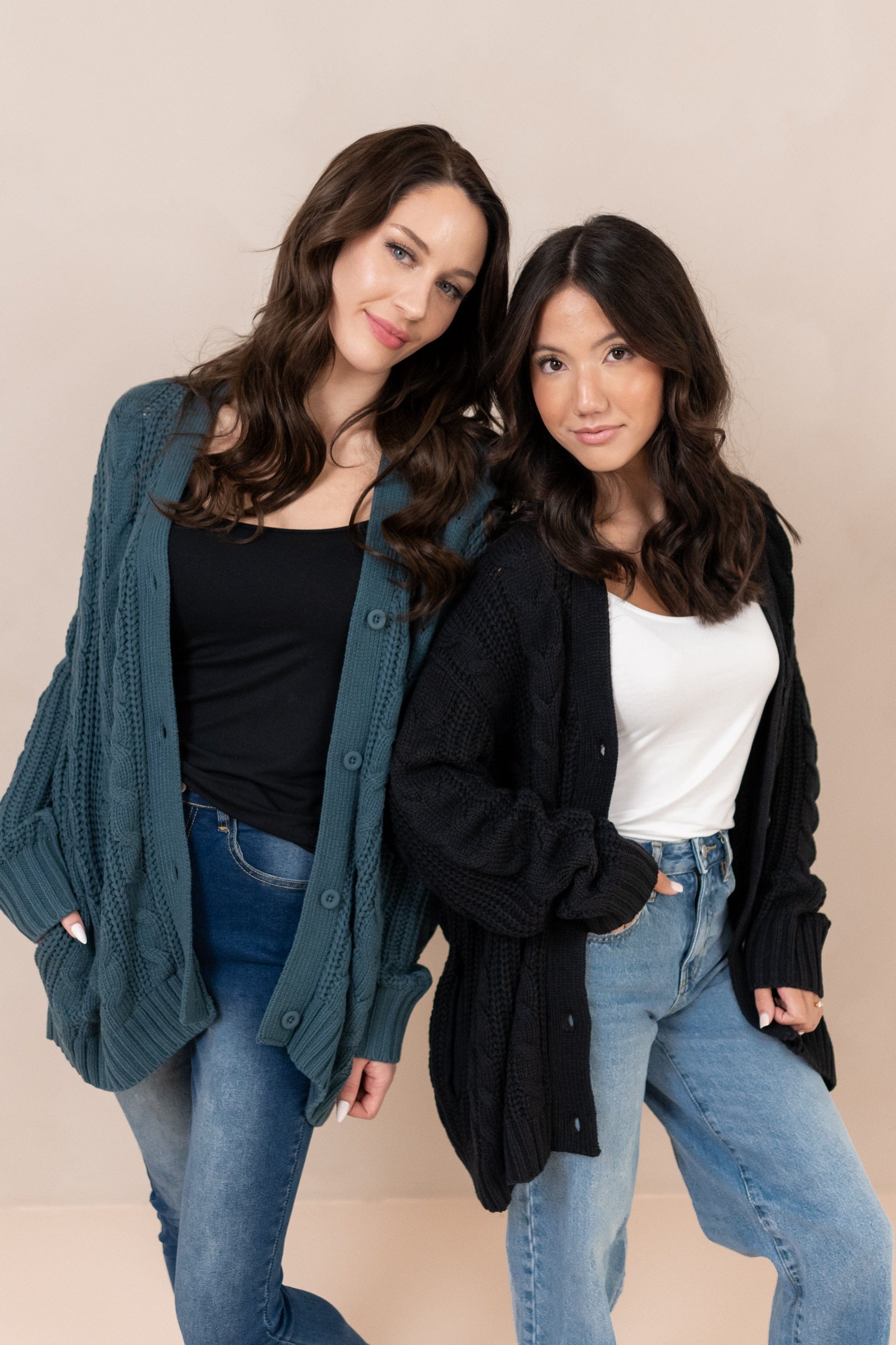 Two females standing side by side wearing the Cable Knit Adult Cardigan in Midnight and Atlantic