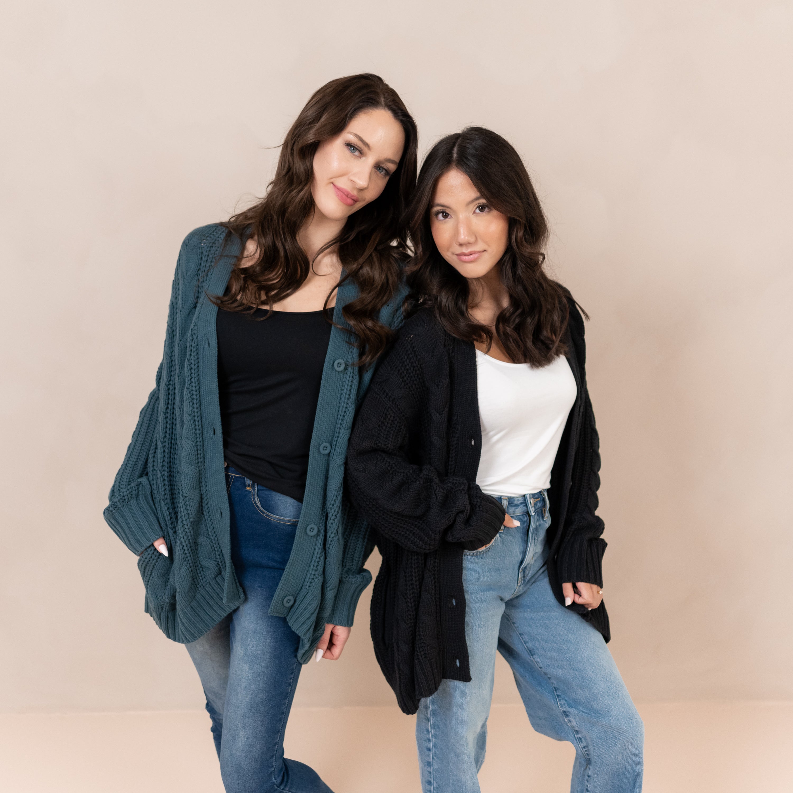 Two females standing side by side wearing the Cable Knit Adult Cardigan in Midnight and Atlantic