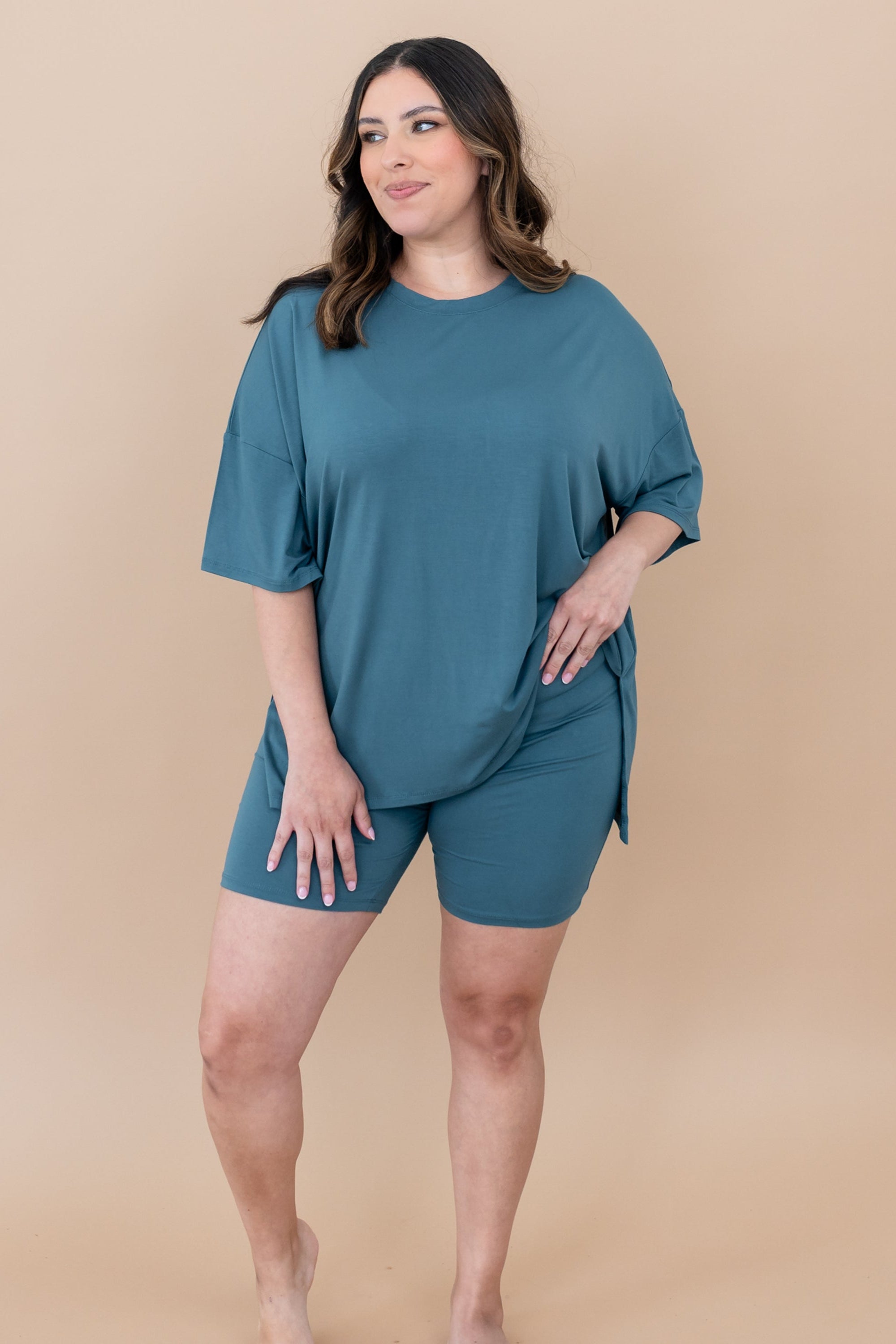 Female looking off to the side with one hand on hip wearing the Women’s Biker Short Set in Atlantic