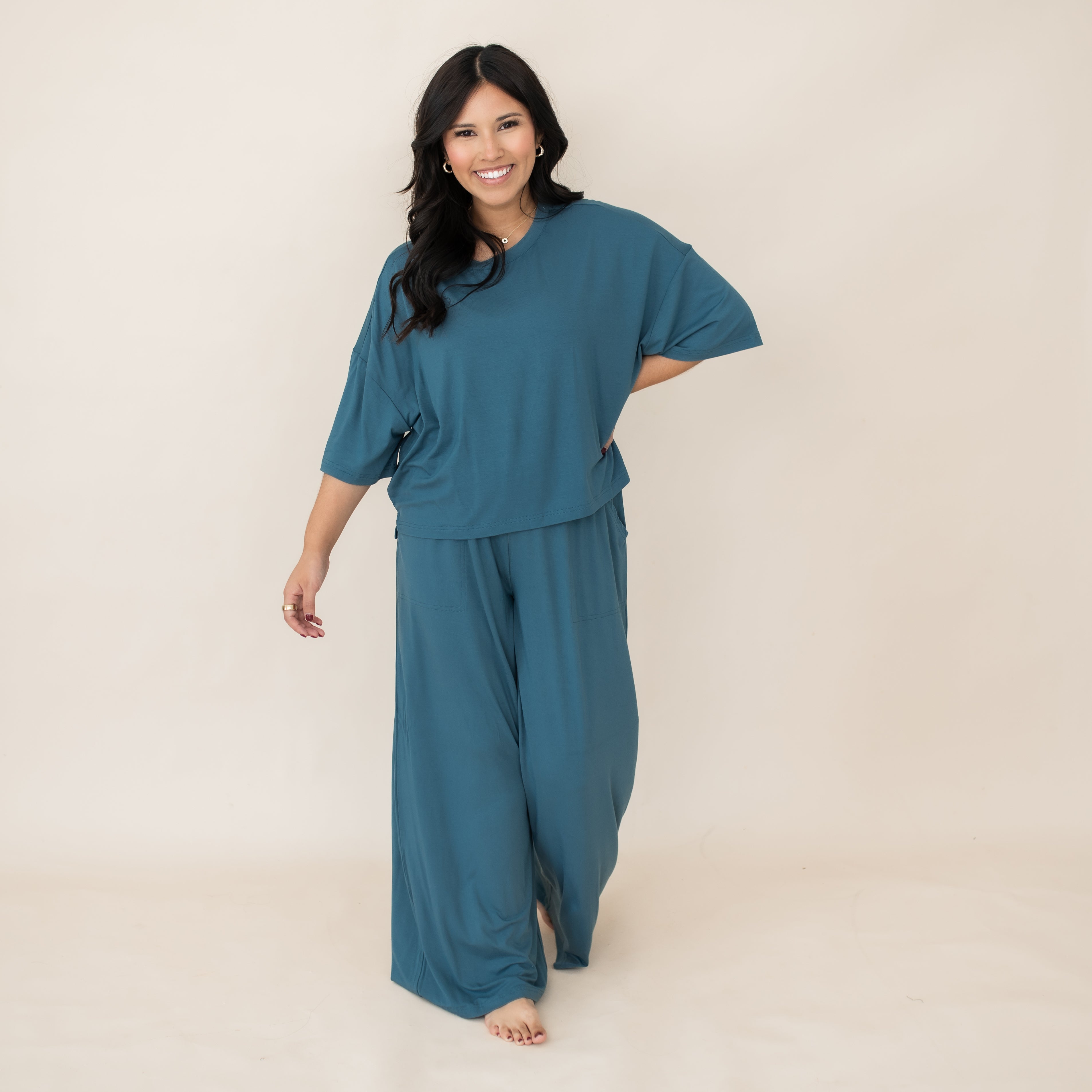 Smiling female walking wearing the Women’s Wide Leg Pant Set in Atlantic in front of a light neutral background