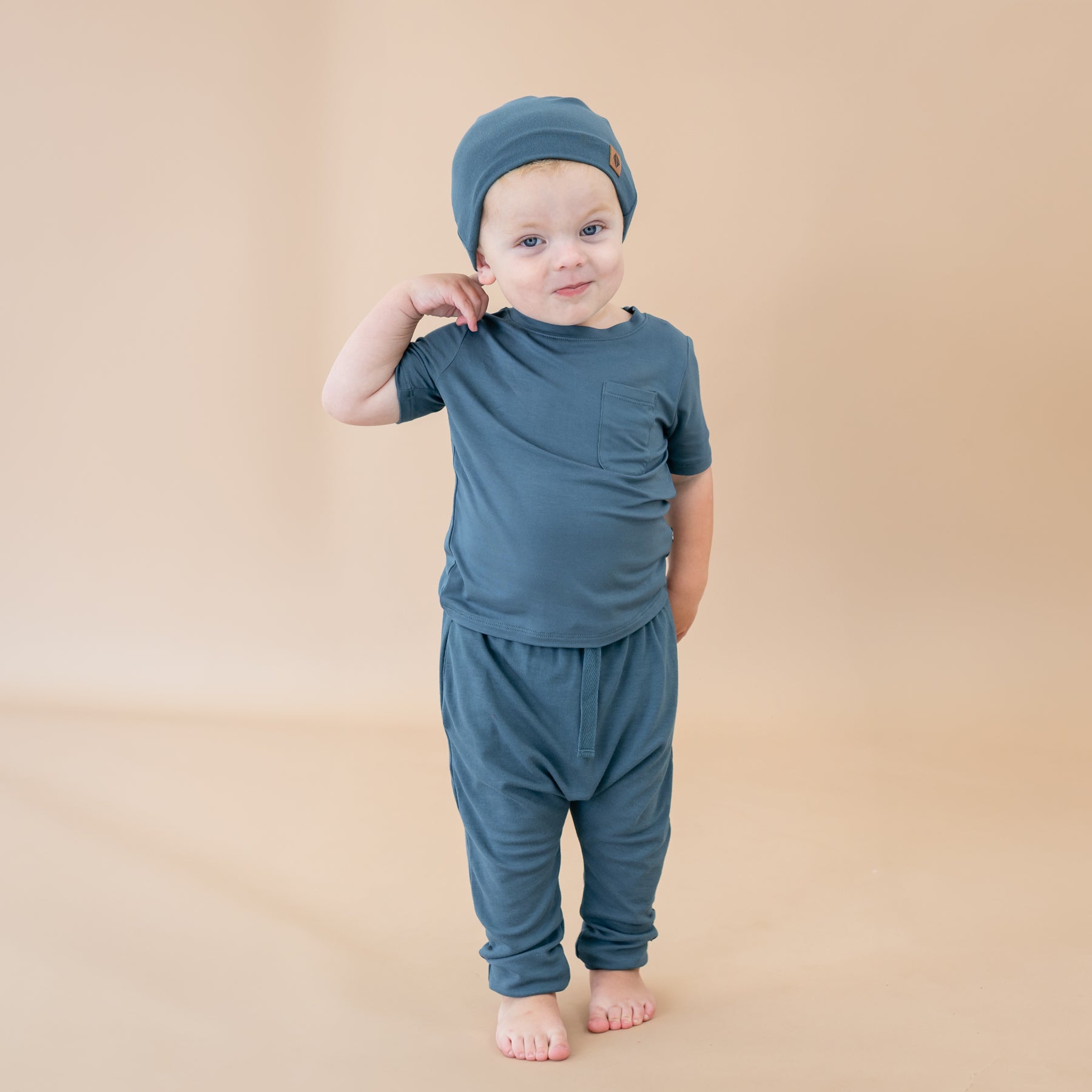 Toddler wearing Bamboo Jersey Beanie in Atlantic with blue crew neck tee and harem pants