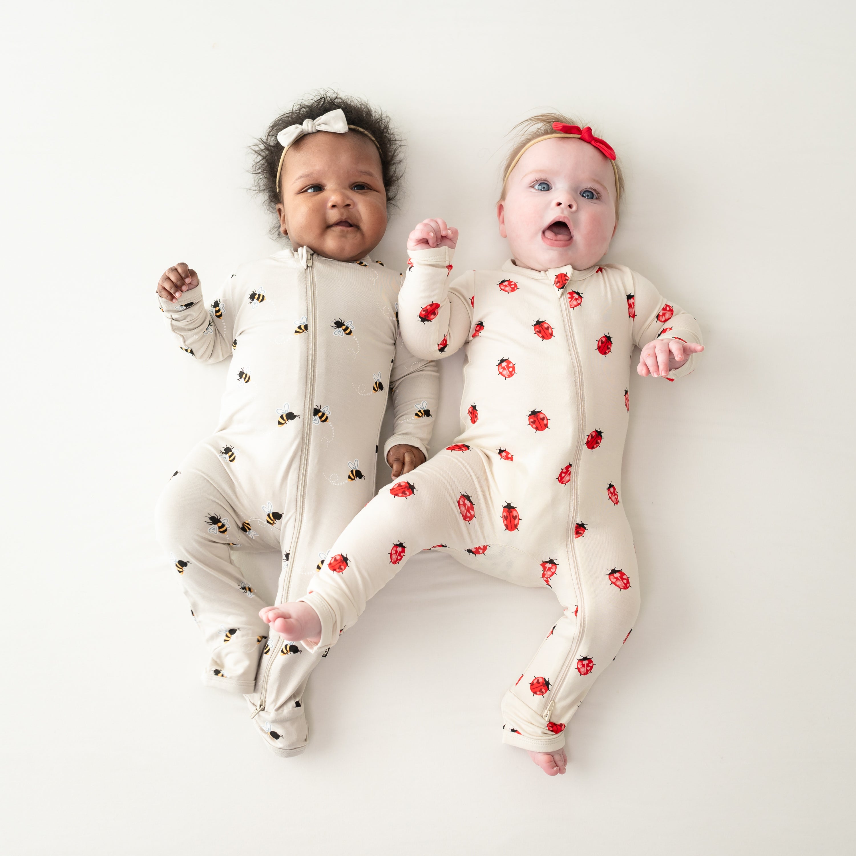 Two babies wearing Zippered Rompers in Bee Mine and Love Bug