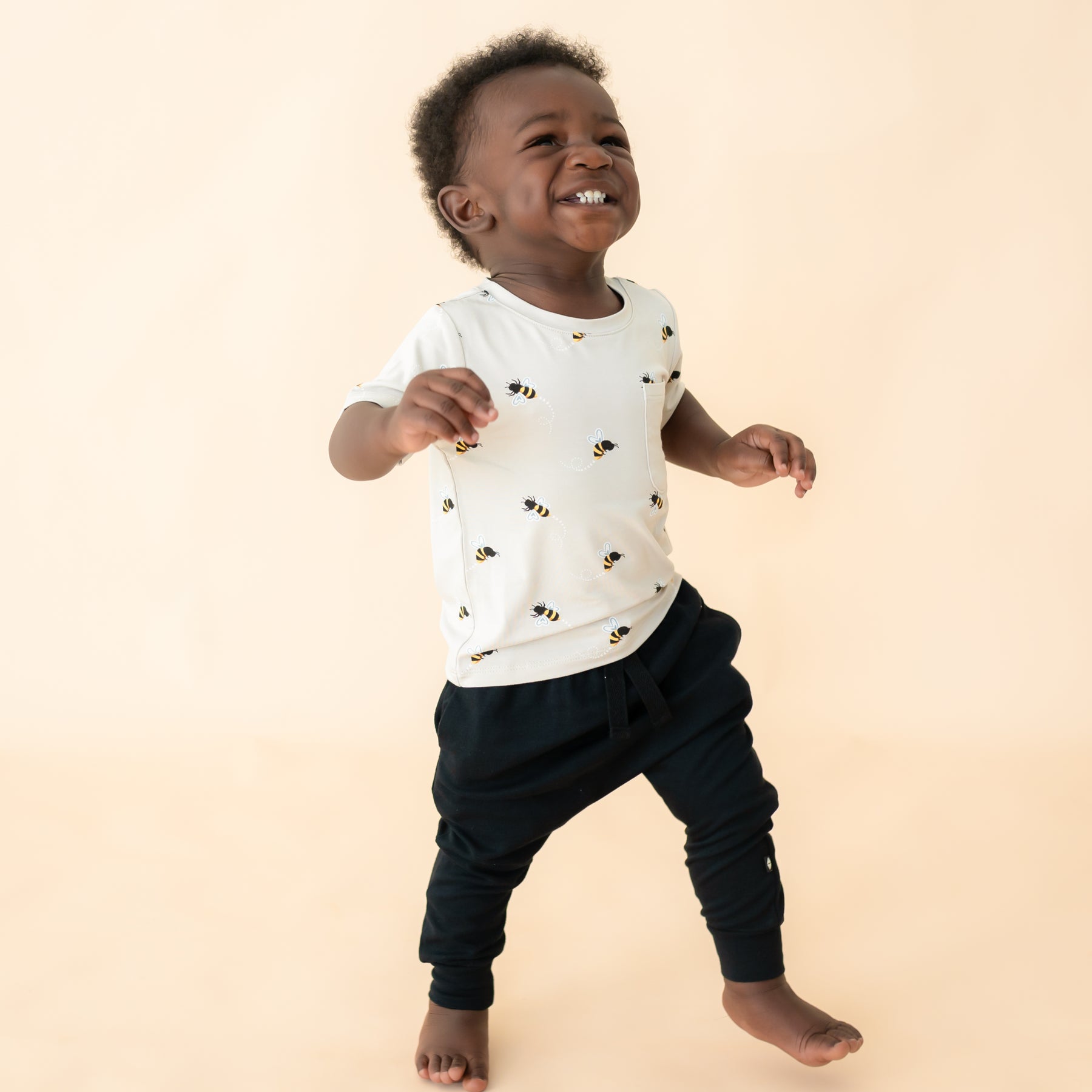 Toddler wearing Bee Mine crew neck tee standing and smiling