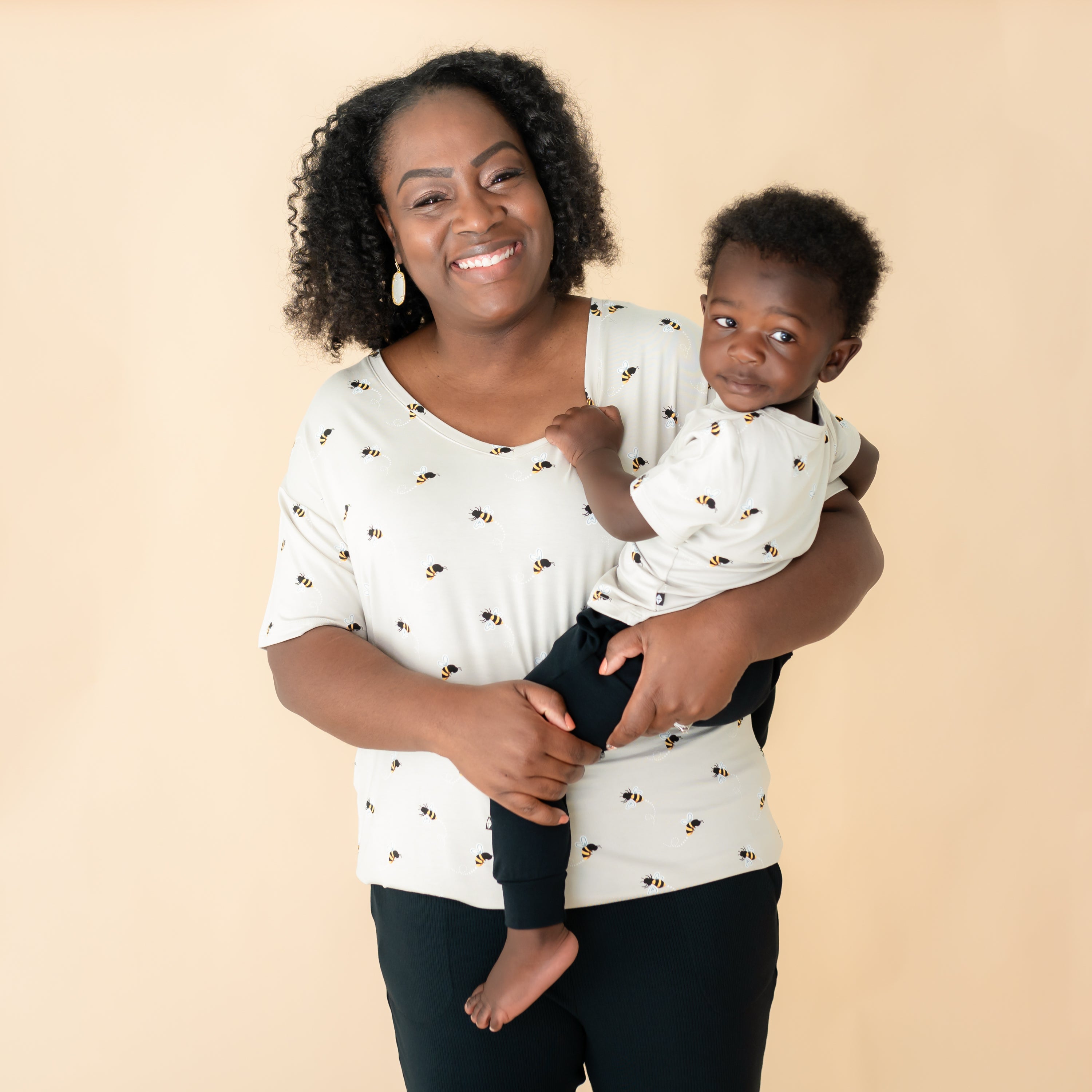 Toddler being held by mom wearing matching Bee Mine tees