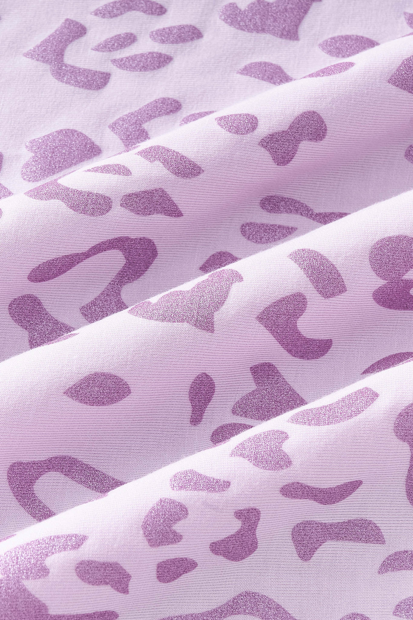 An all-over, monochromatic leopard print with purple spots over a pinkish lilac background color named Thistle.
