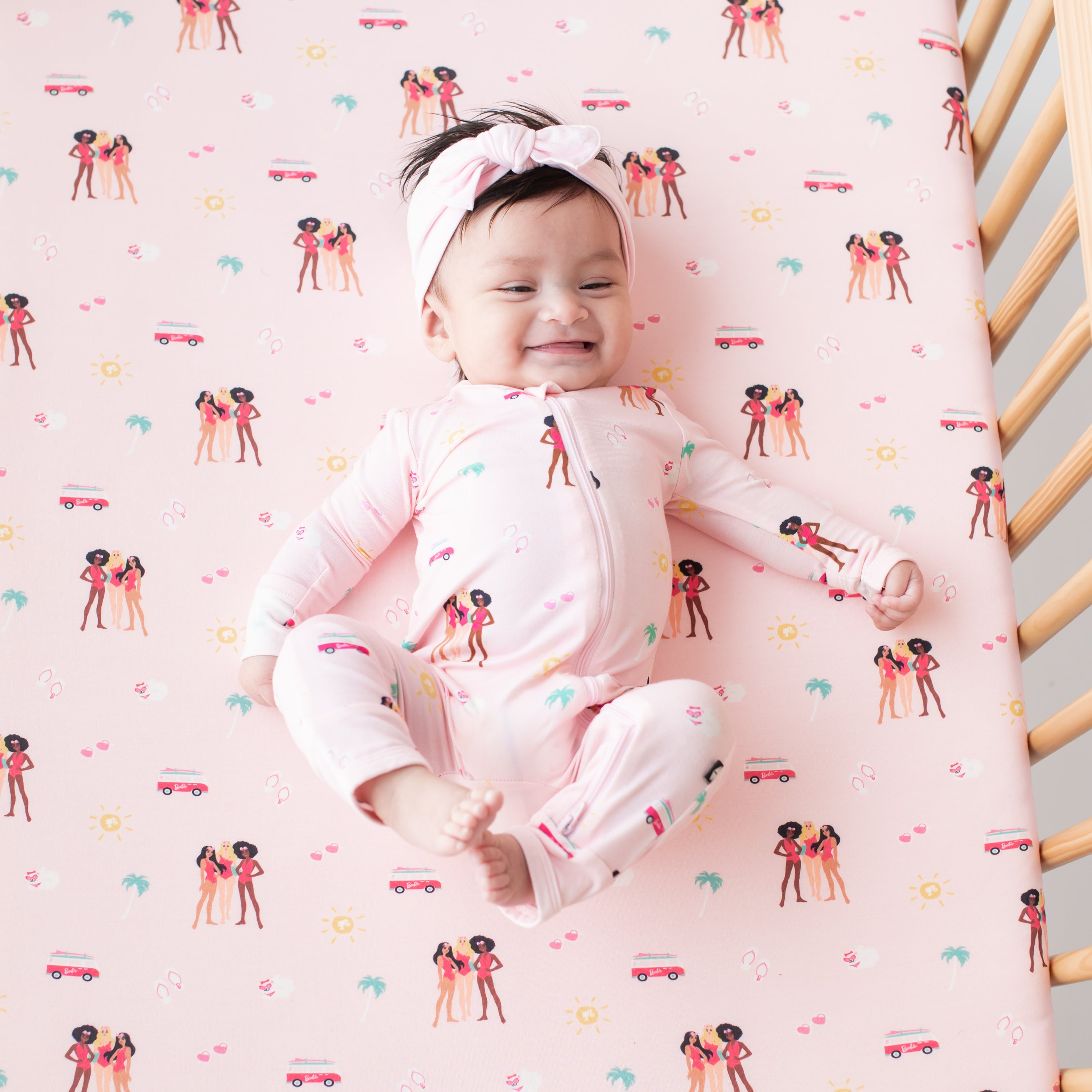 Baby in a crib with Crib Sheet in Barbie™ Beach on wearing Barbie™ Beach zippered romper