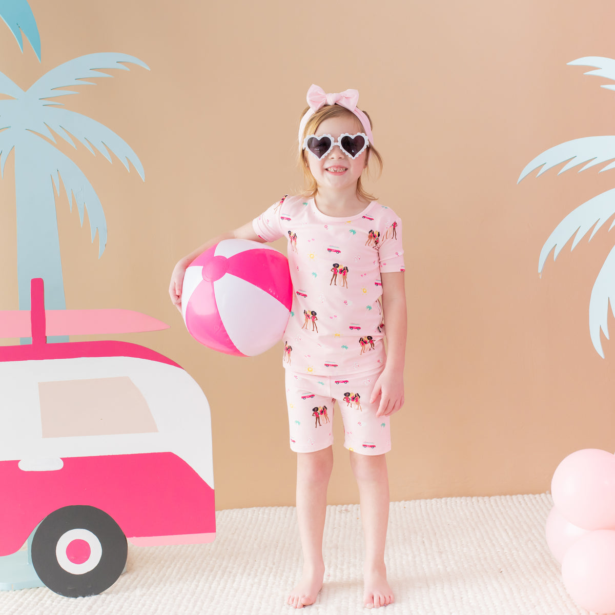 Child modeling Short Sleeve Pajamas in Barbie™ Beach with beach ball