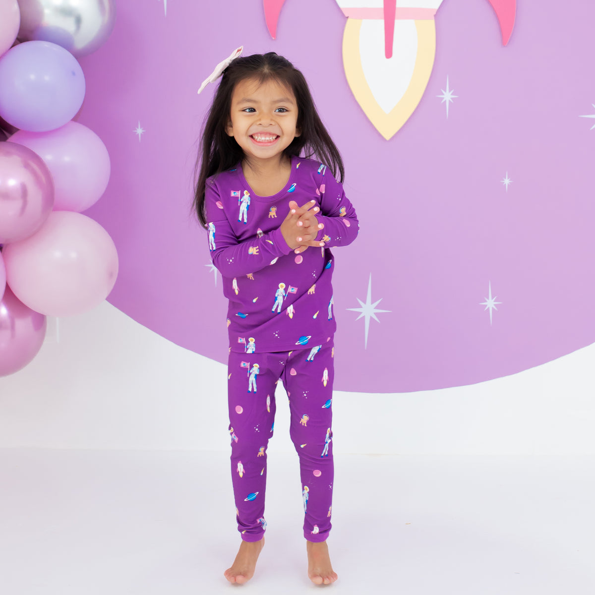 Toddler smiling wearing Long Sleeve Pajamas in Barbie™ Astronaut