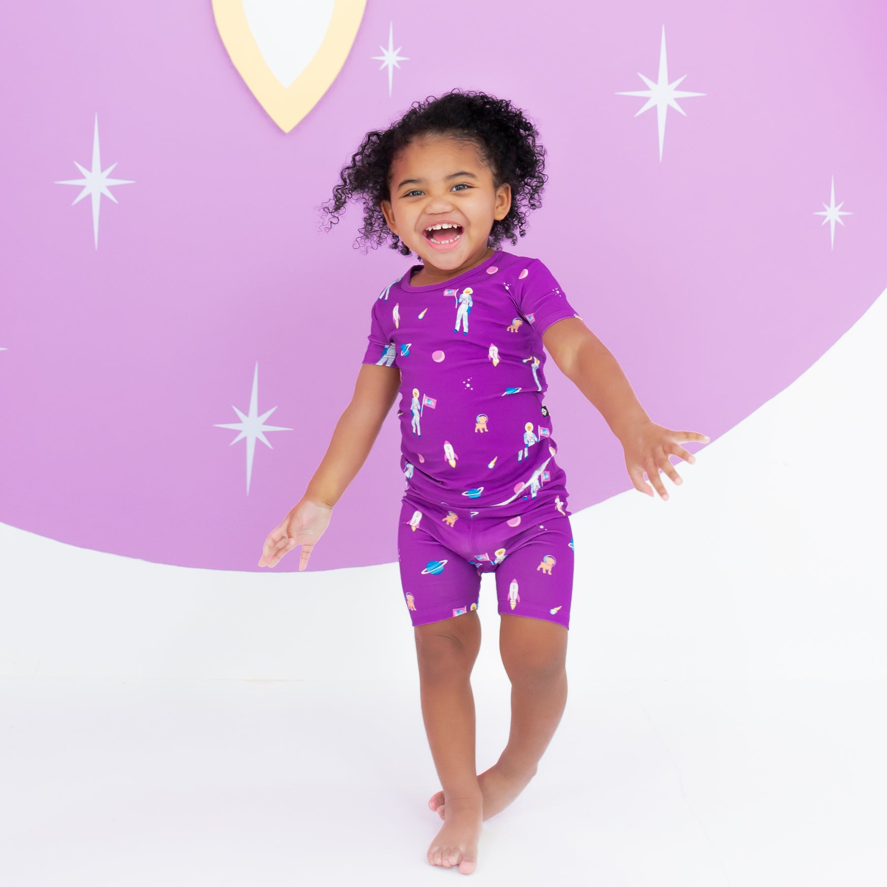 Toddler smiling wearing Short Sleeve Pajamas in Barbie™ Astronaut