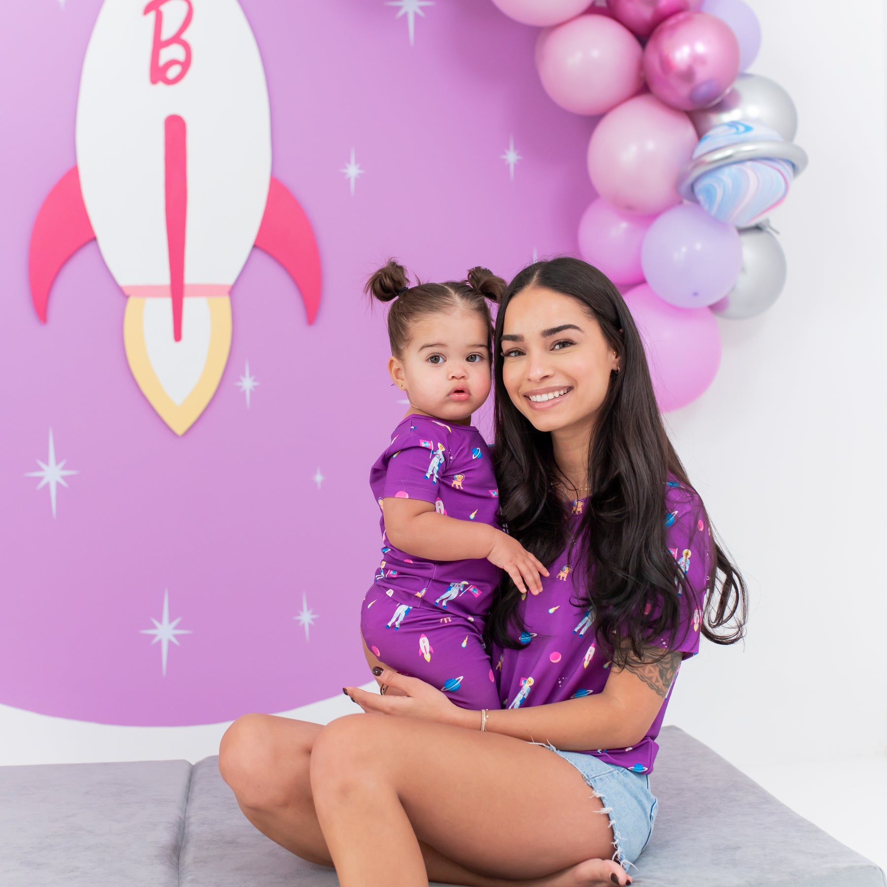 Toddler wearing Short Sleeve Pajamas in Barbie™ Astronaut sitting with mom 