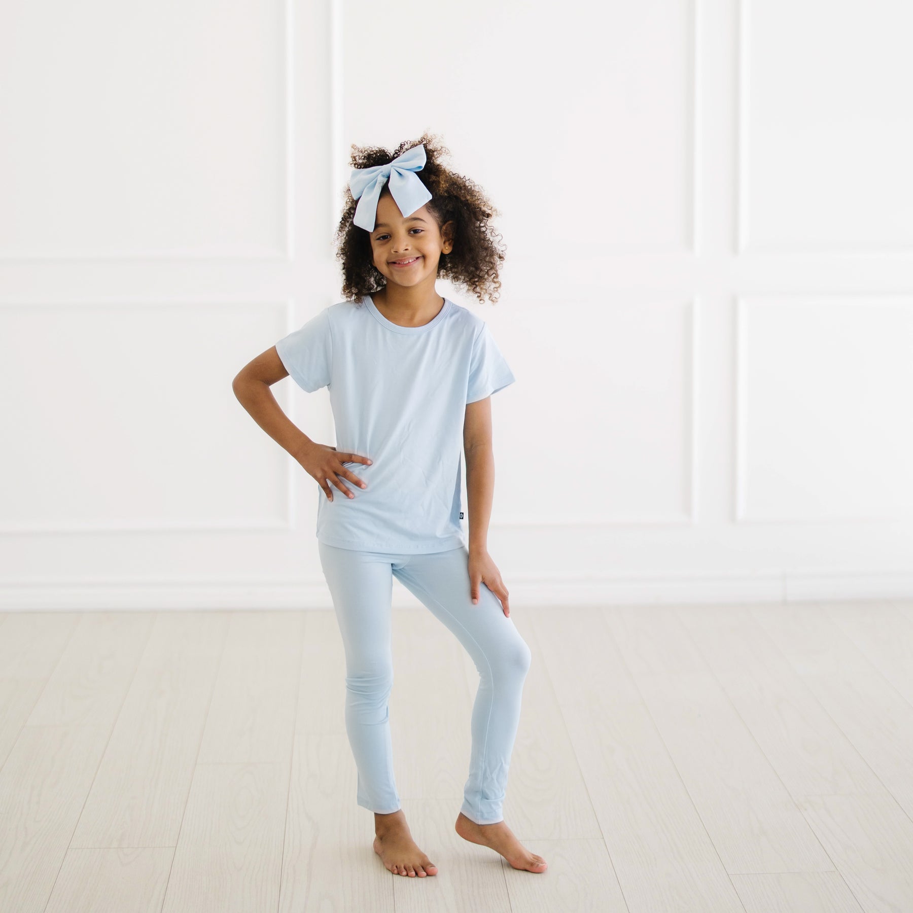 Young girl posing wearing the Toddler Basic Tee in Breeze with matching leggings