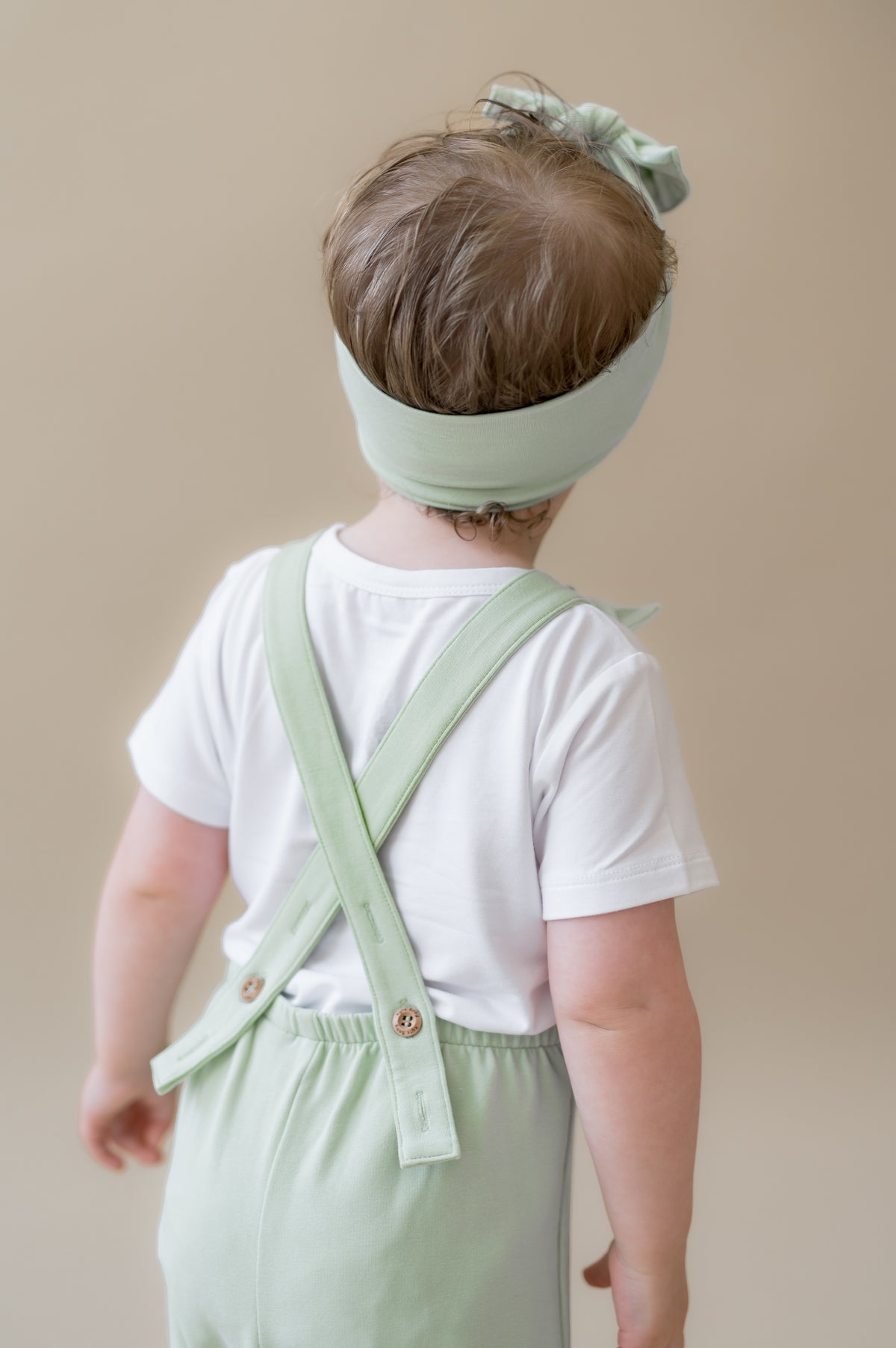 The back of the Overall in Basil showing the back cross removable straps