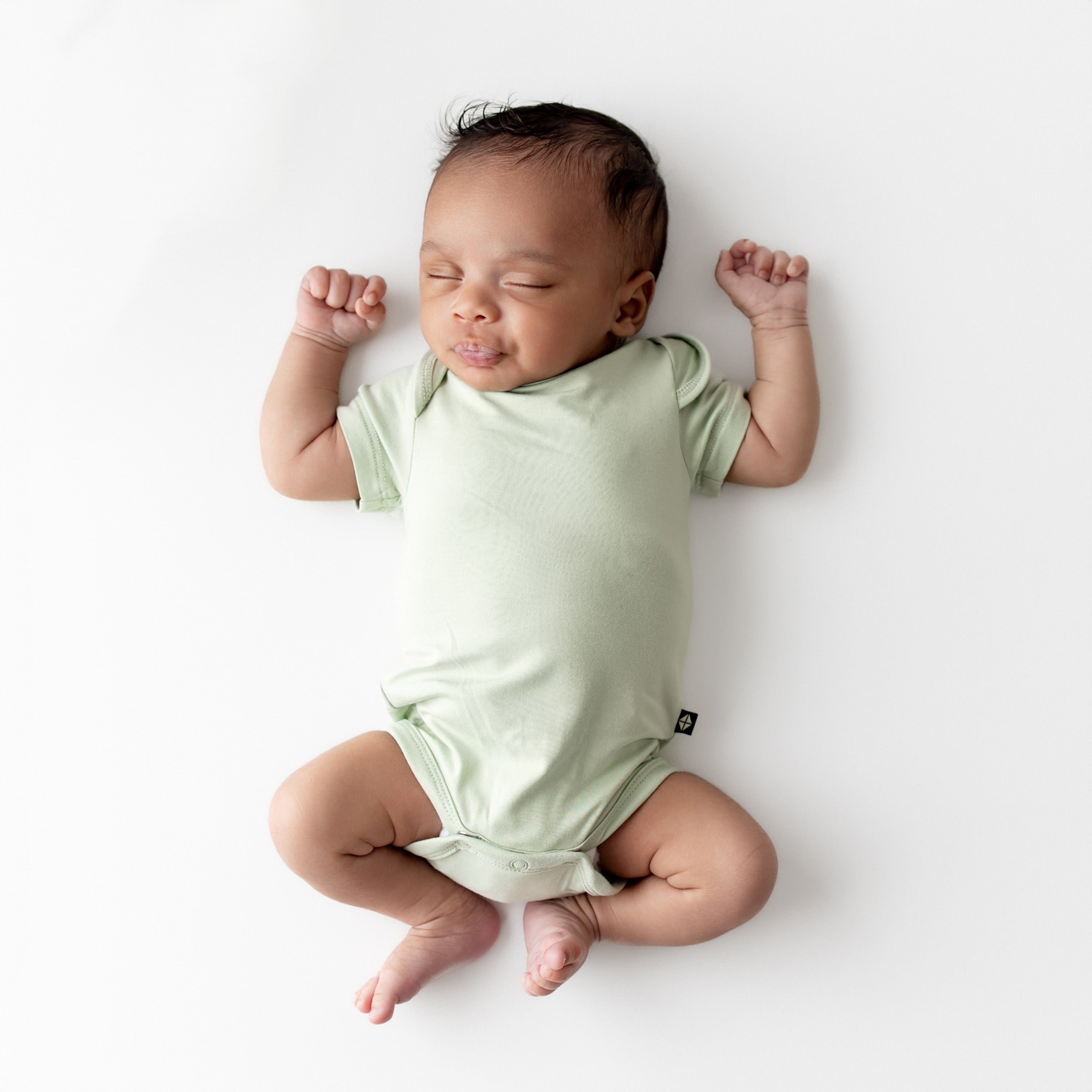 Baby wearing a light green bodysuit