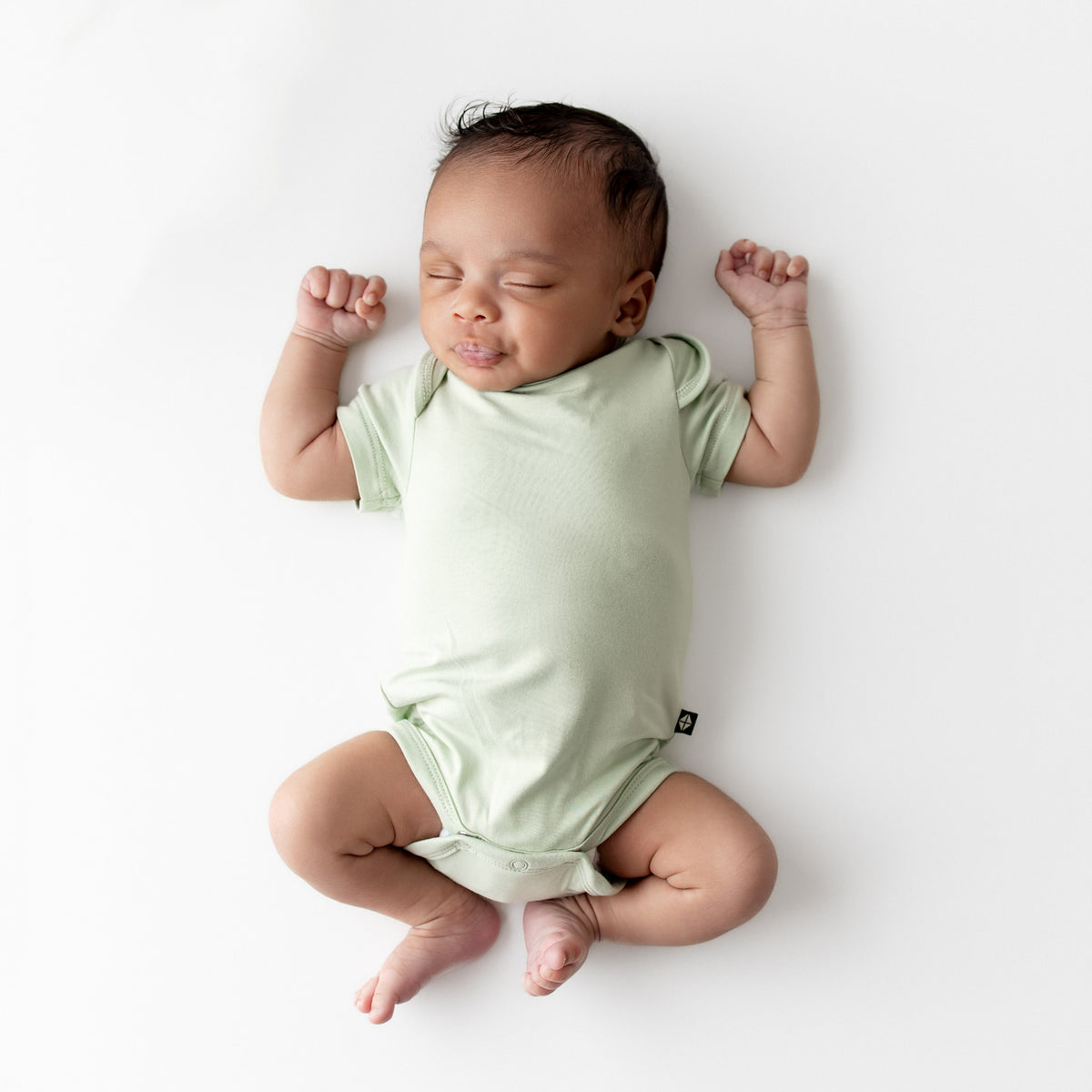 Baby wearing a light green bodysuit