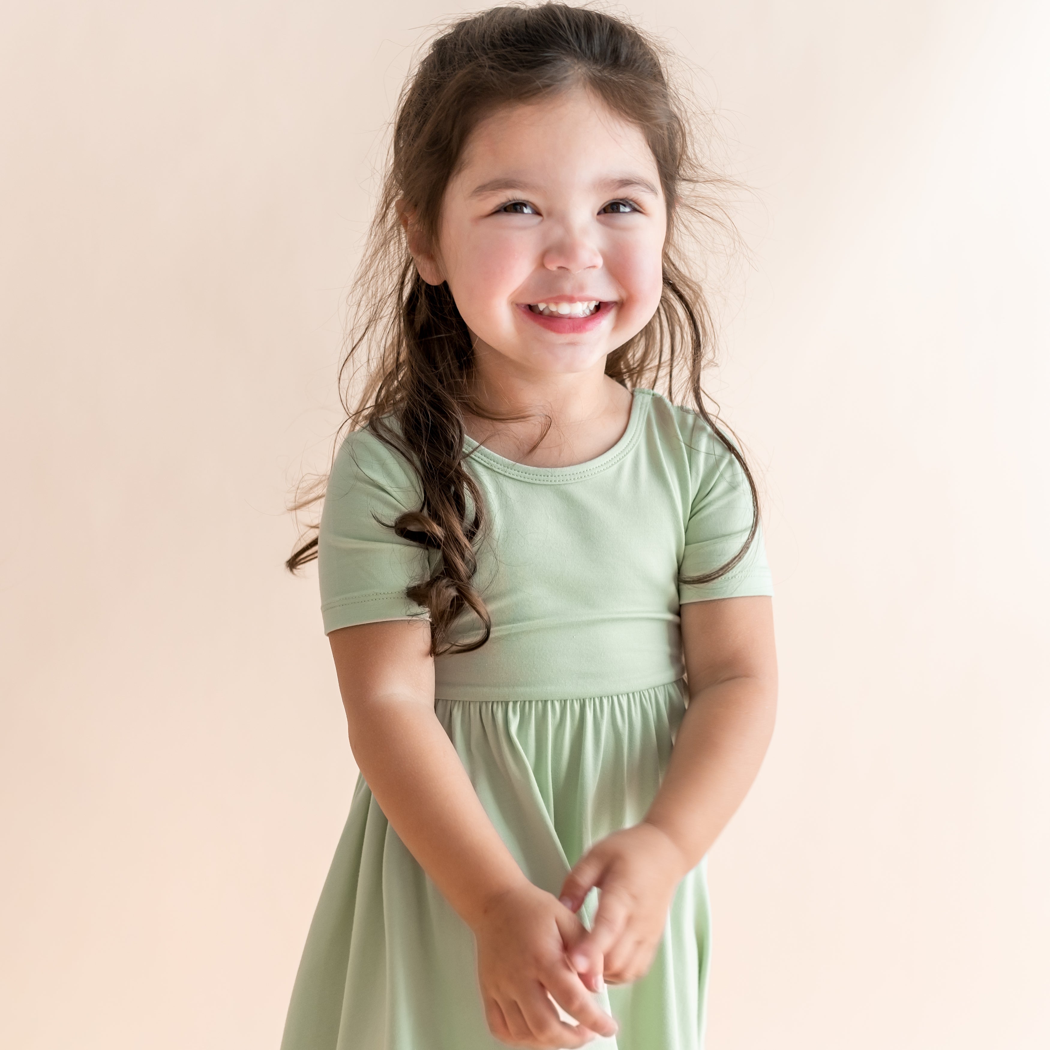 Close up of young girl wearing light green colored short sleeve dress