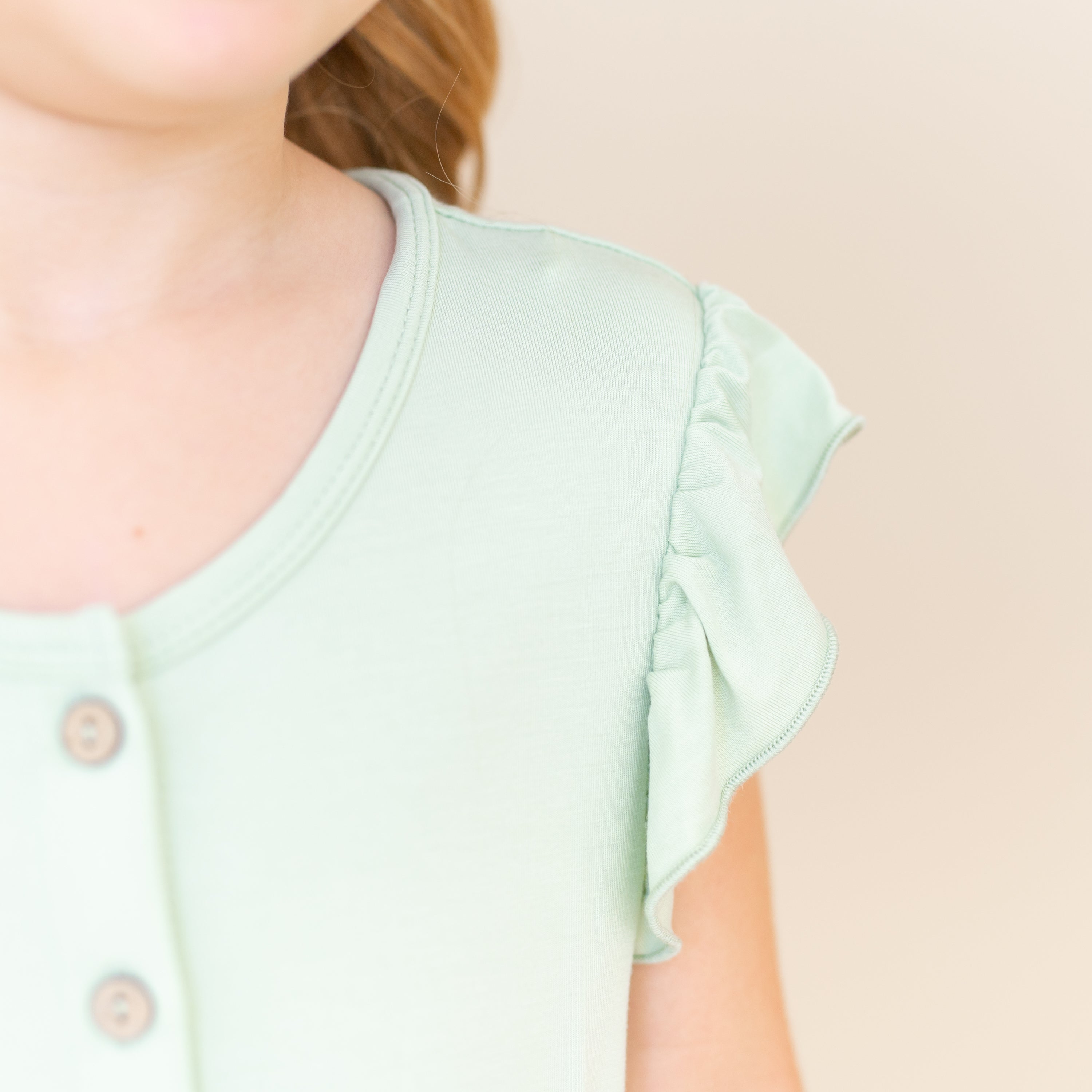 Close up of the flutter sleeve detail on the Flutter Sleeve Romper in Basil