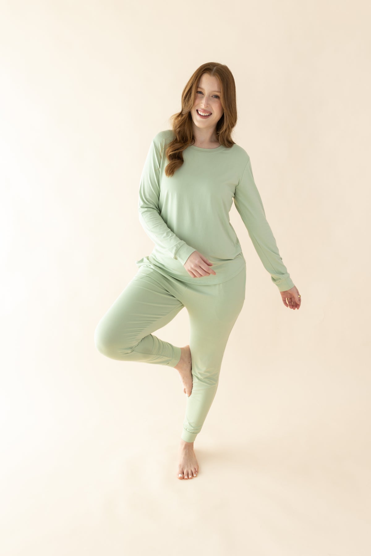 Female posing wearing the Women's Jogger Pajama Set in Basil in front of a light neutral background