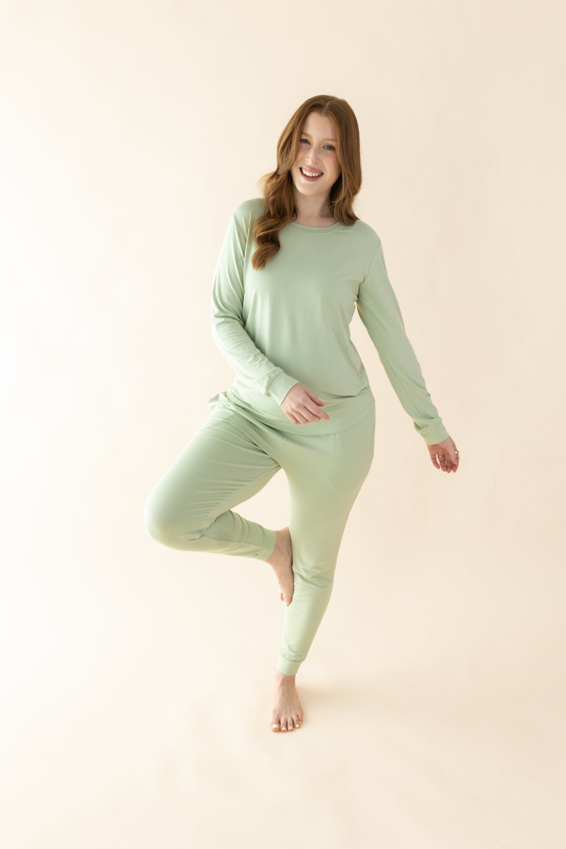 Female posing wearing the Women's Jogger Pajama Set in Basil in front of a light neutral background