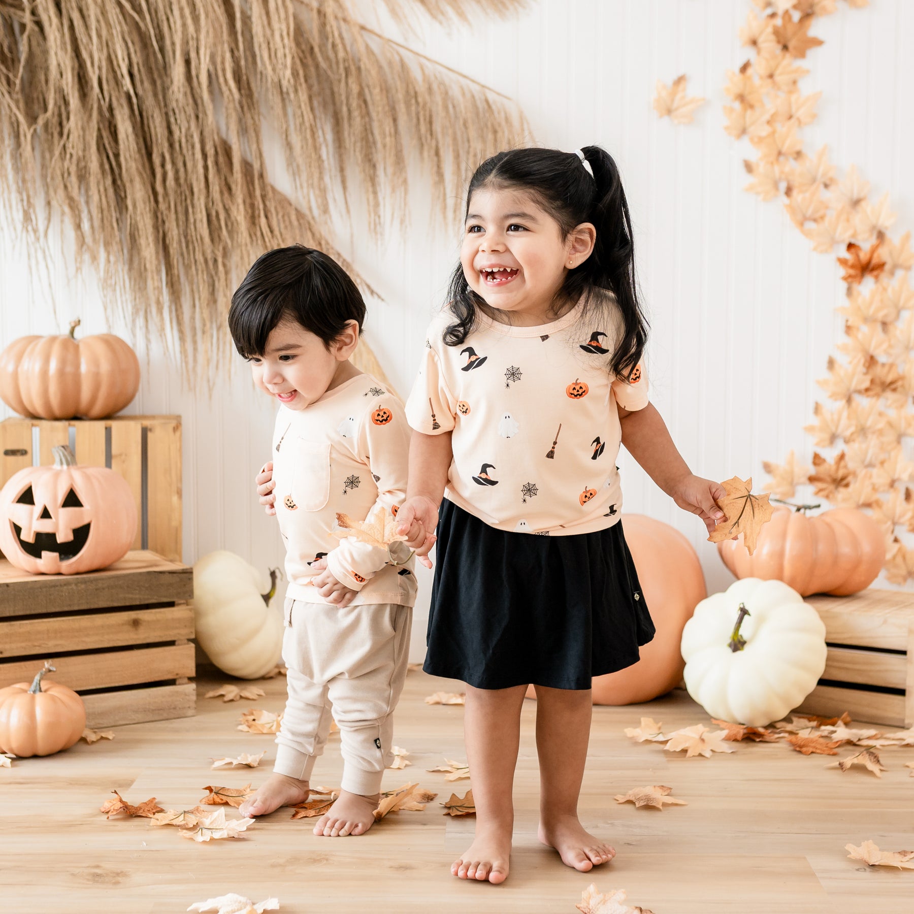 Two toddlers standing beside each other wearing the Toddler Basic Tee and long sleeve crew neck  in Bewitched