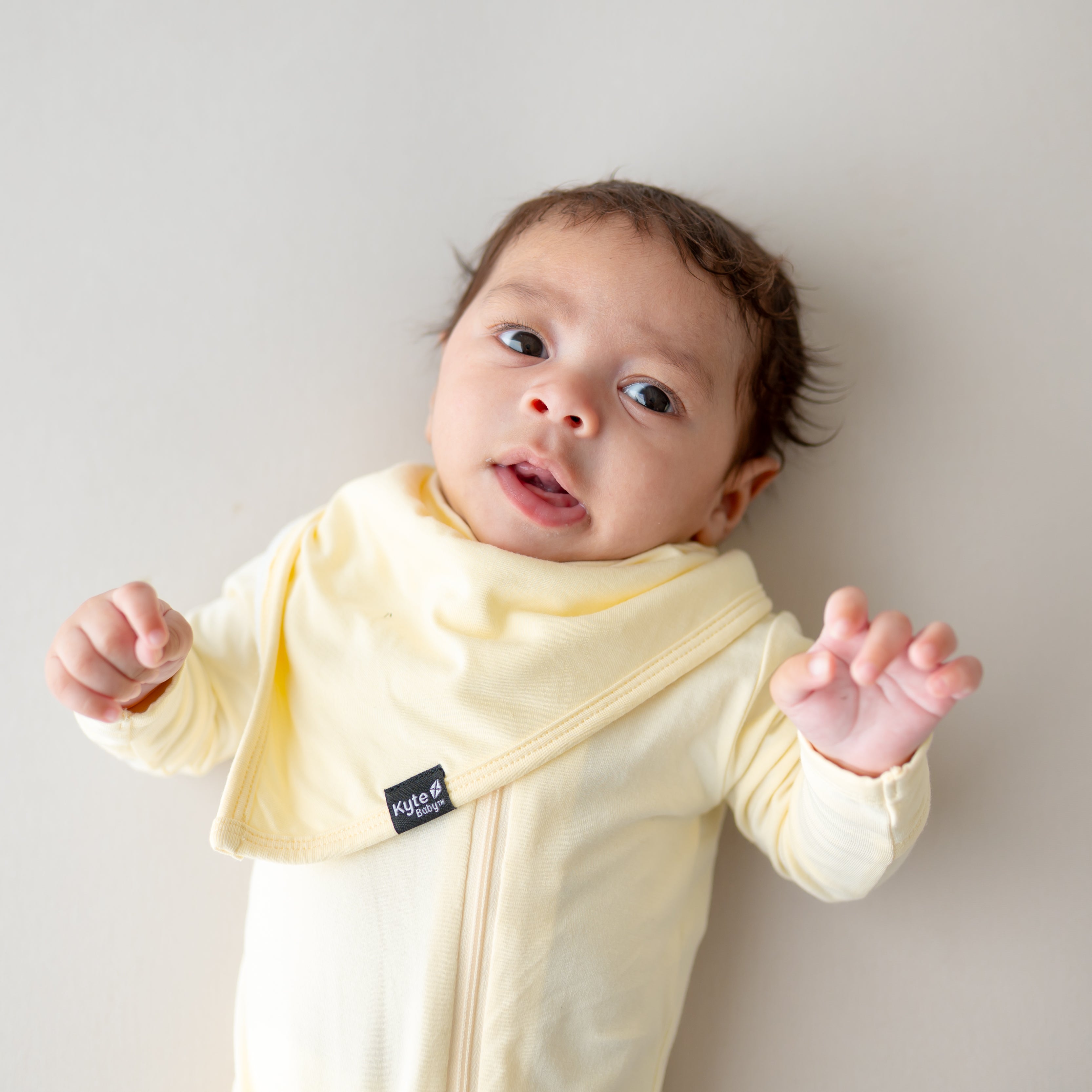 Baby wearing a yellow bib and matching romper