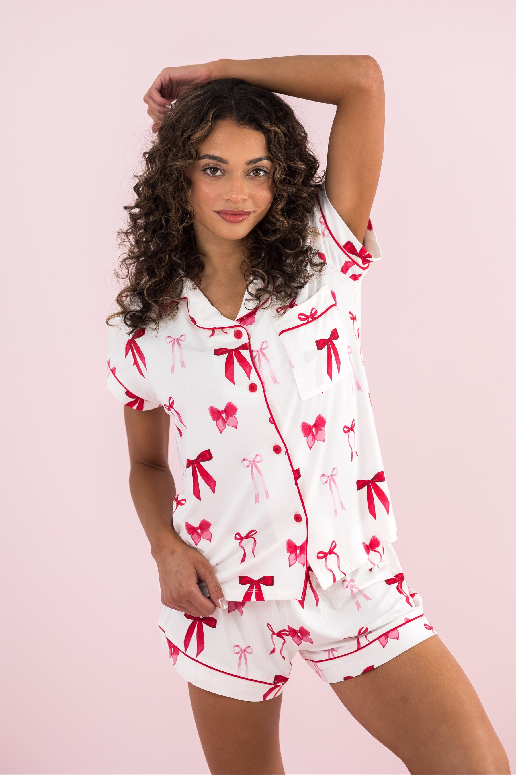Woman modeling the Bamboo Women's Short Sleeve Pajama Set in Big Love Bow with hand over her head