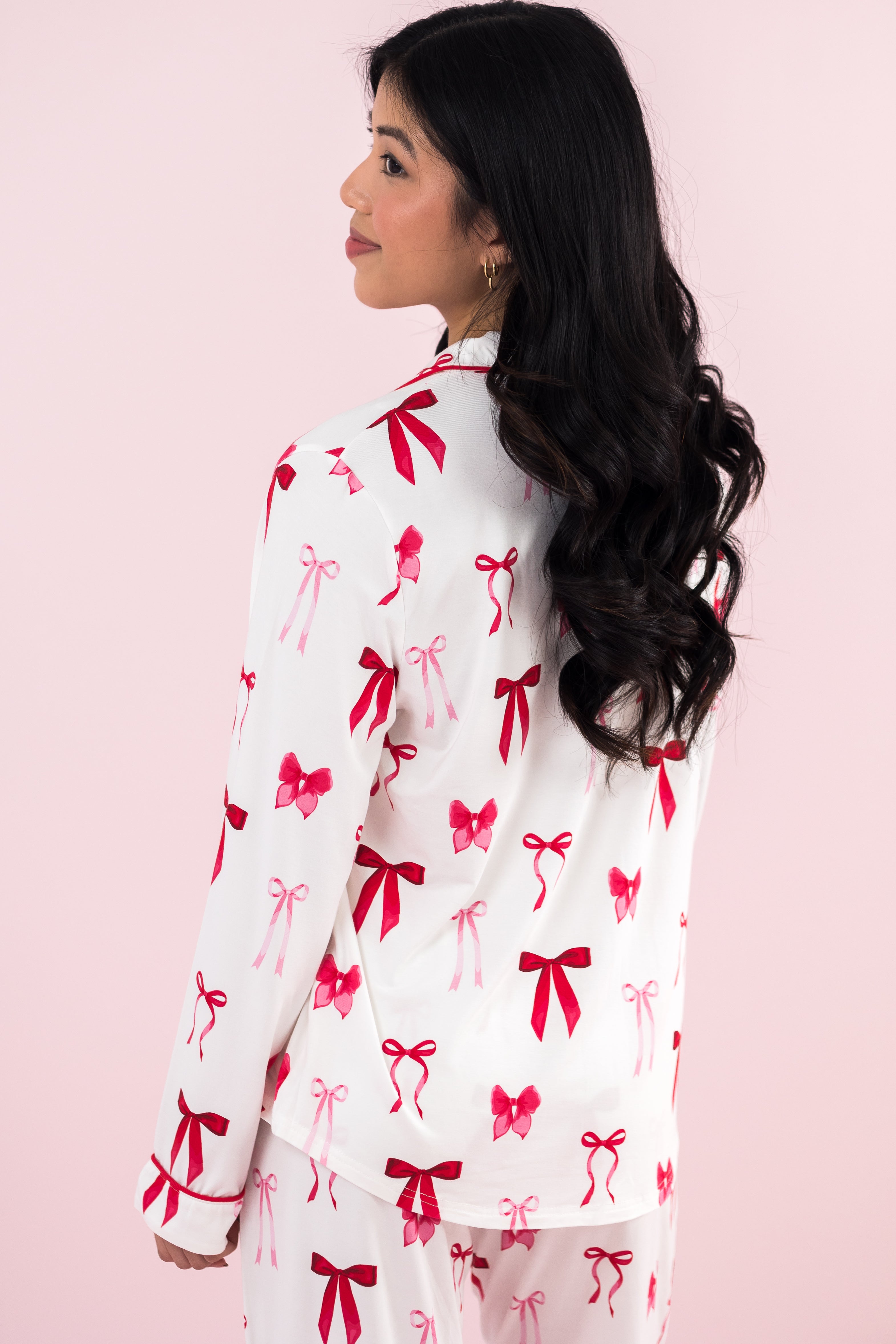 Model with her back to the camera wearing the Long-Sleeved Women's Pajama Set in Big Love Bow