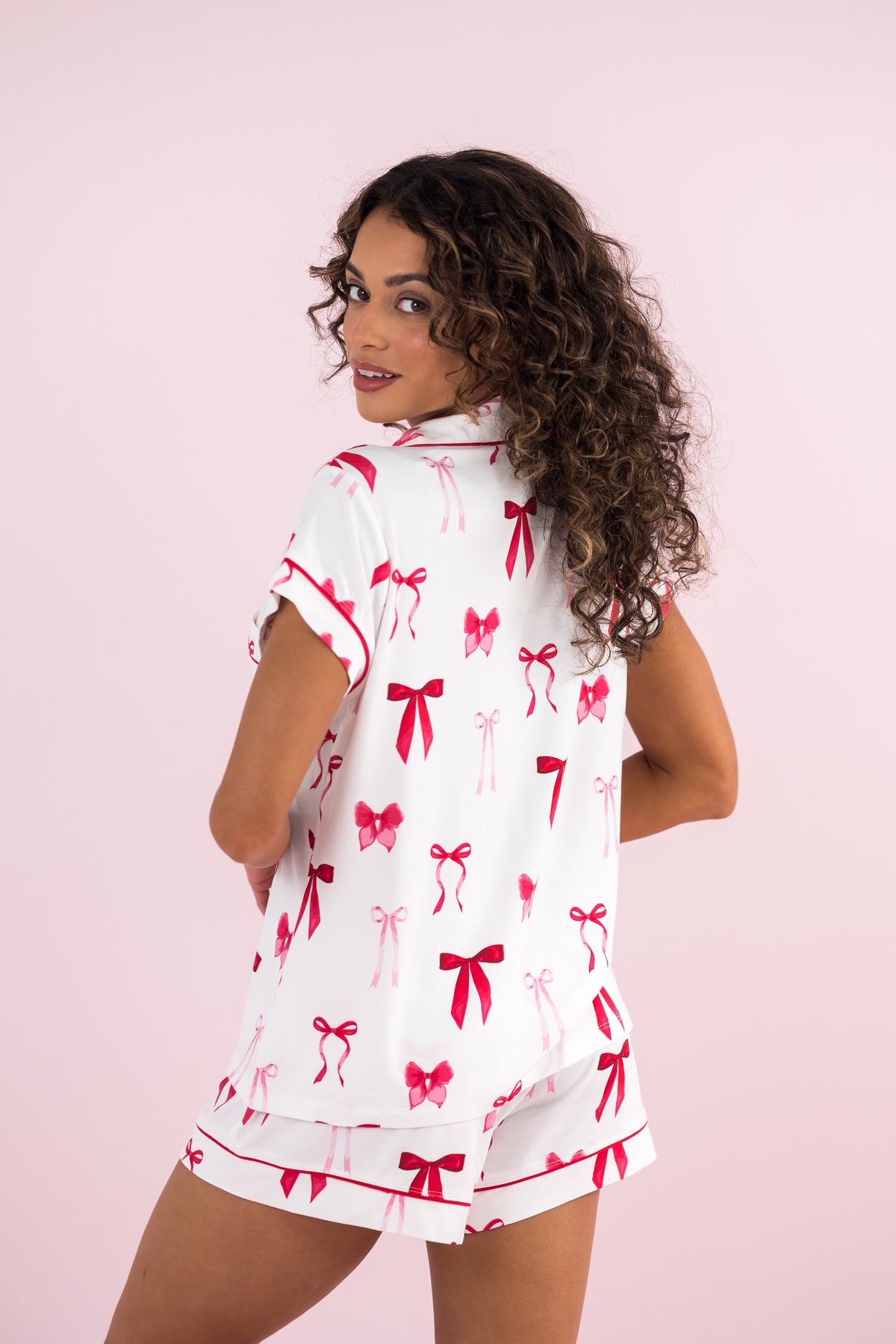Female model wearing the Women's Short Sleeve Pajama Set in Big Love Bow with her back to the camera 