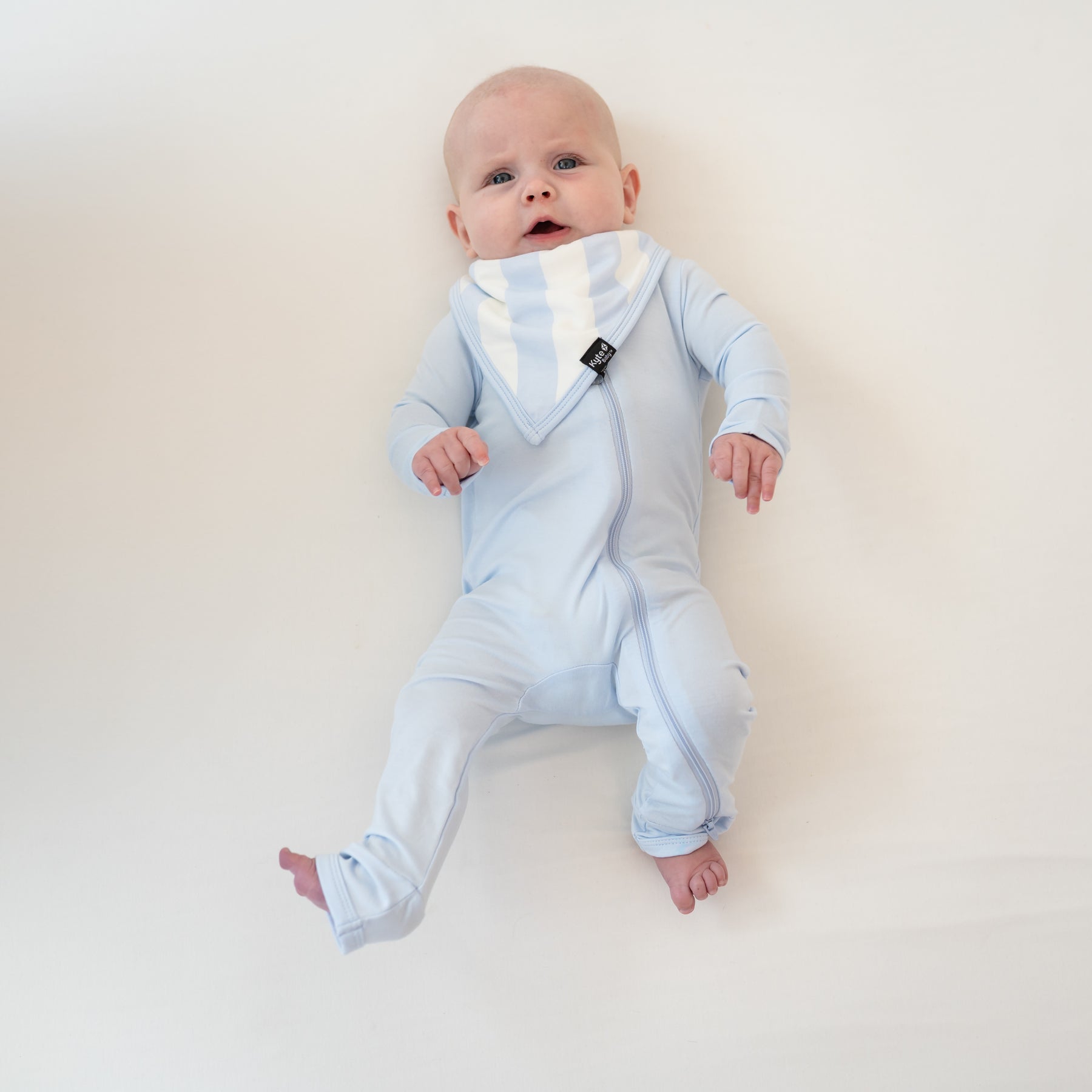 Infant wearing a Mist Zippered Romper paired with a Bib in Big Mist Stripe