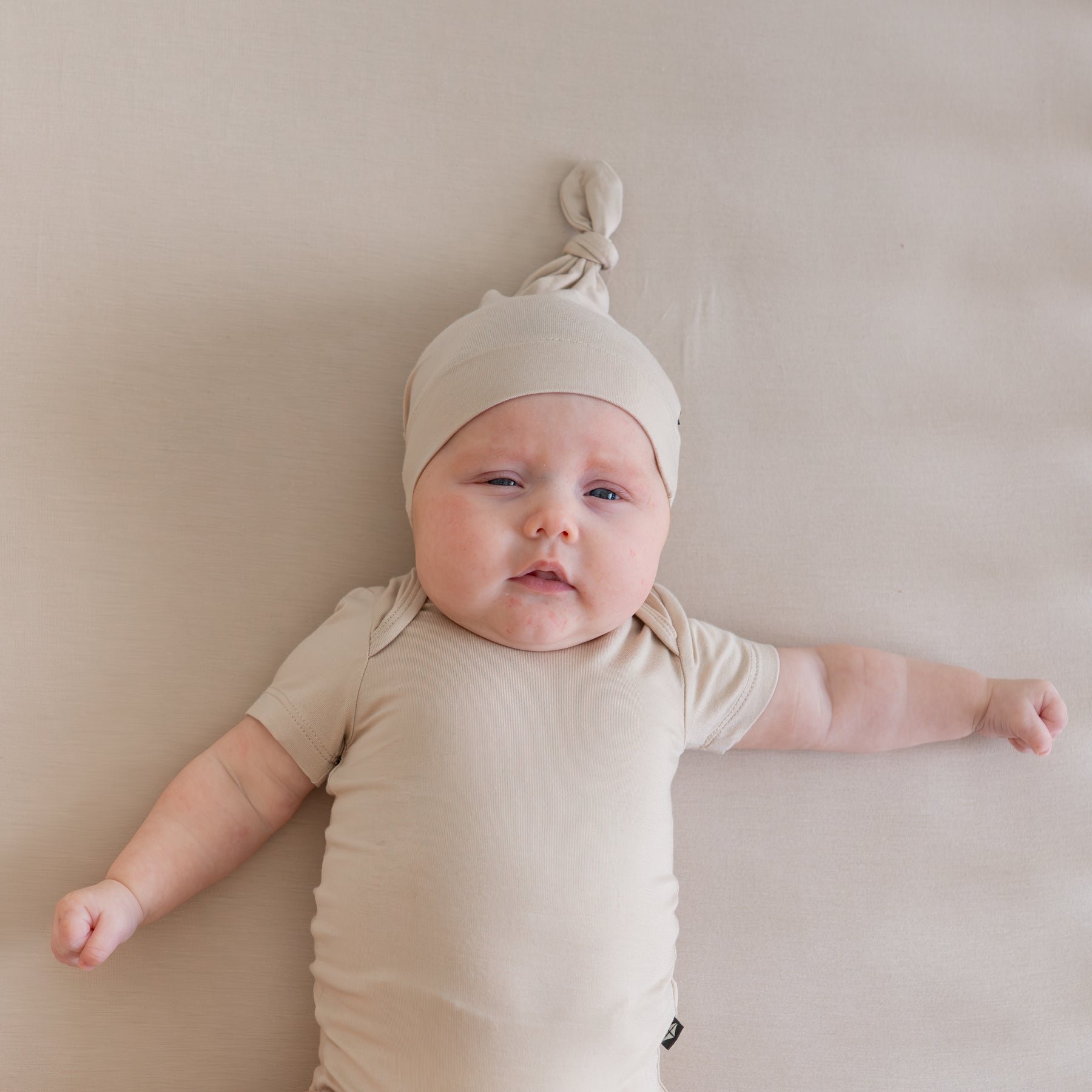 Baby wearing Knotted Cap in Bisque and matching unisex onesie