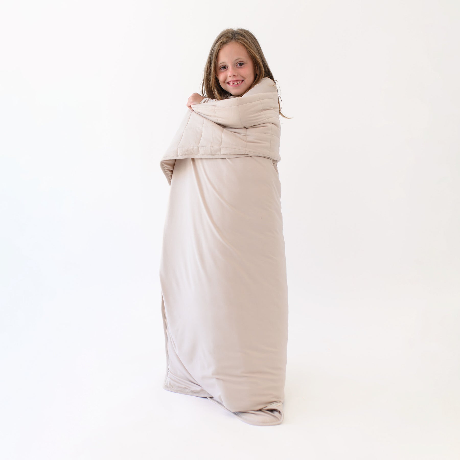 Smiling model standing completely wrapped in a Youth Blanket in Bisque 2.5