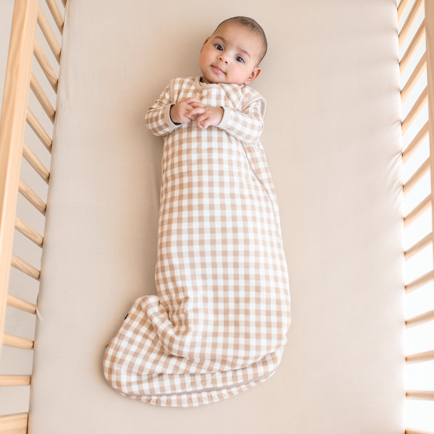 Infant wearing TOG 1.0 Sleep Bag in Gingham Bisque with matching pajamas