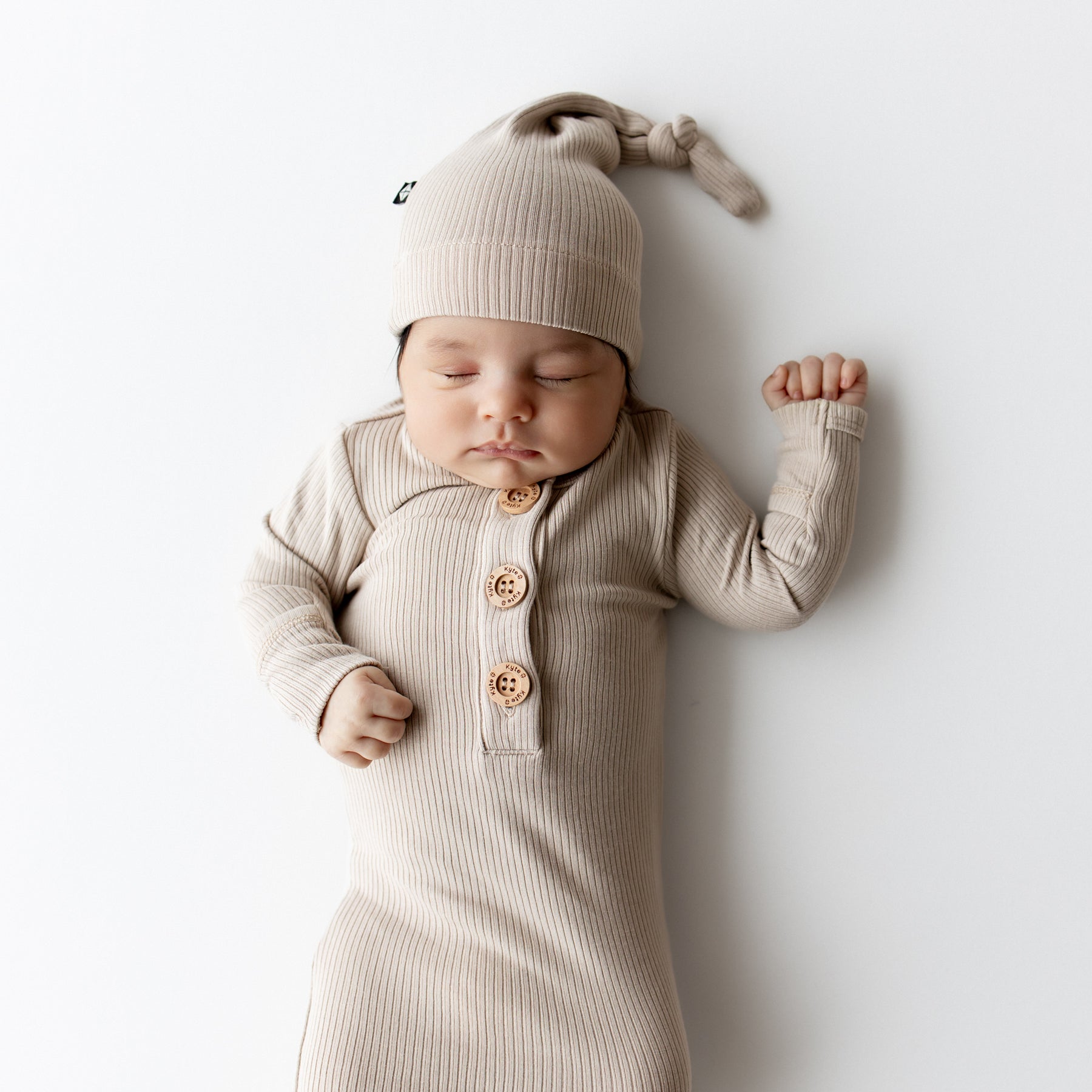 Close up of sleeping infant wearing the Ribbed Knotted Gown with Hat Set in Bisque
