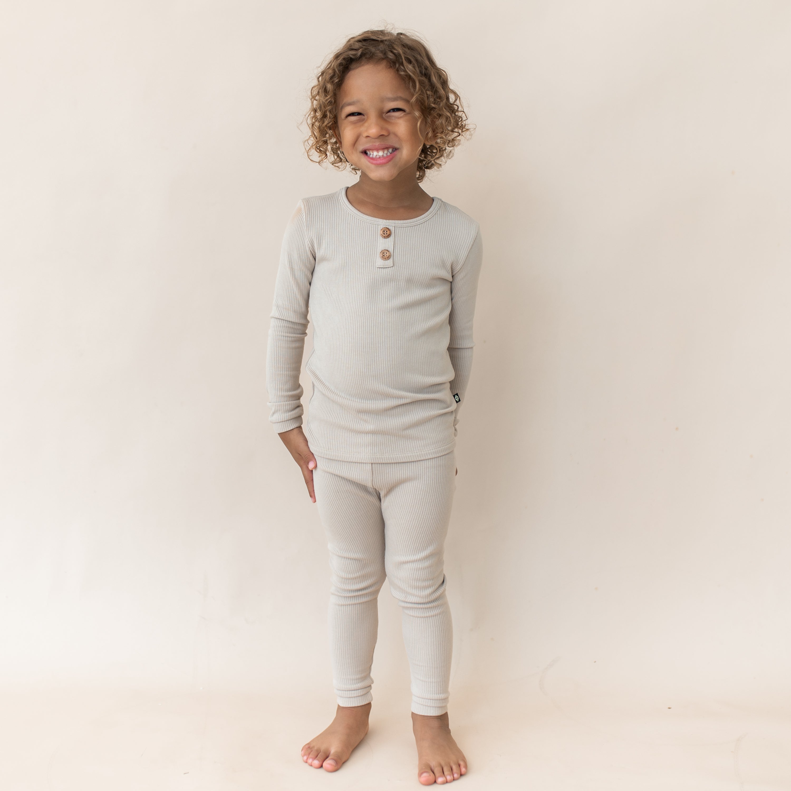 Smiling young girl wearing the Ribbed Henley Set in Bisque